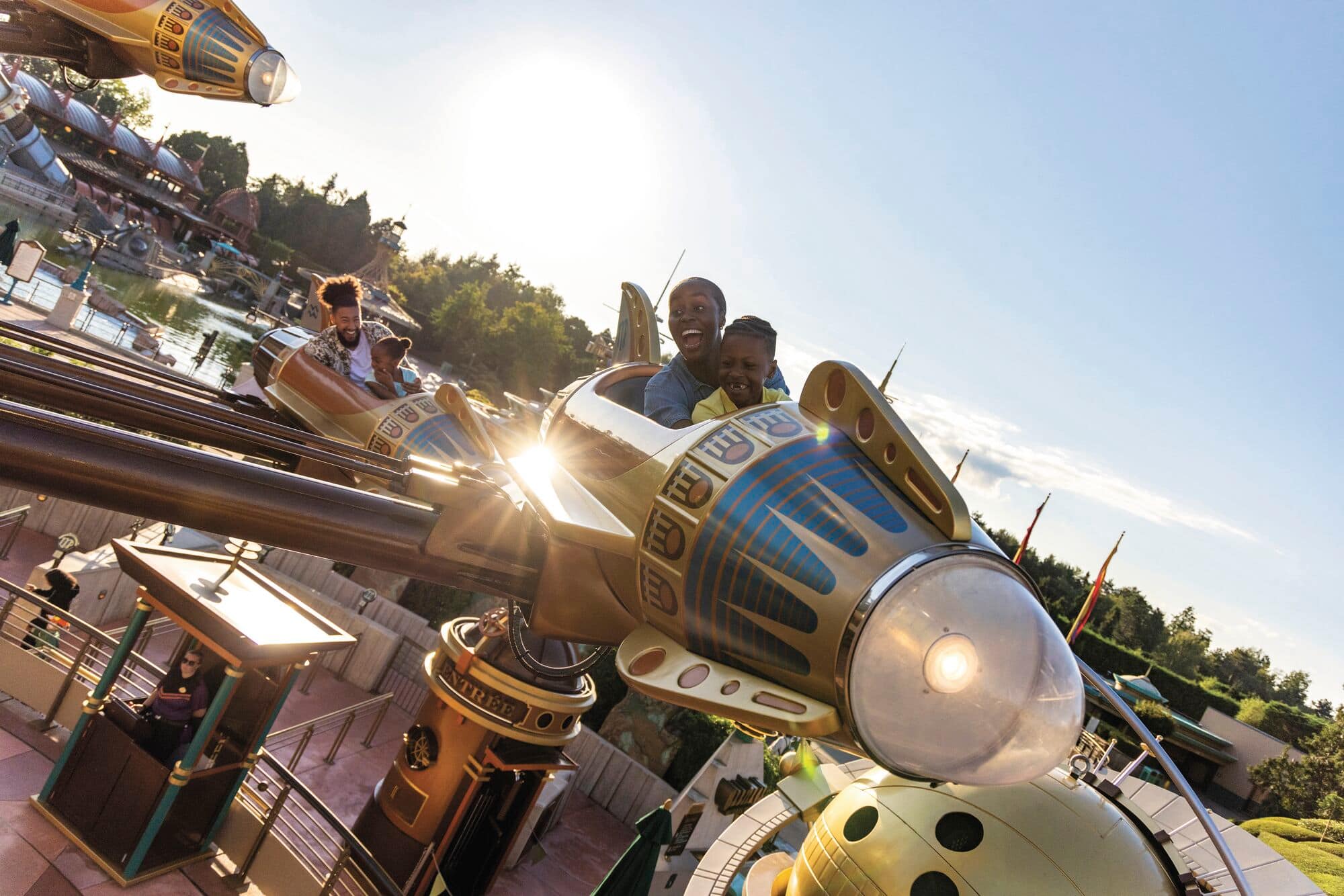 A family smiling and riding the Astro Orbiter.