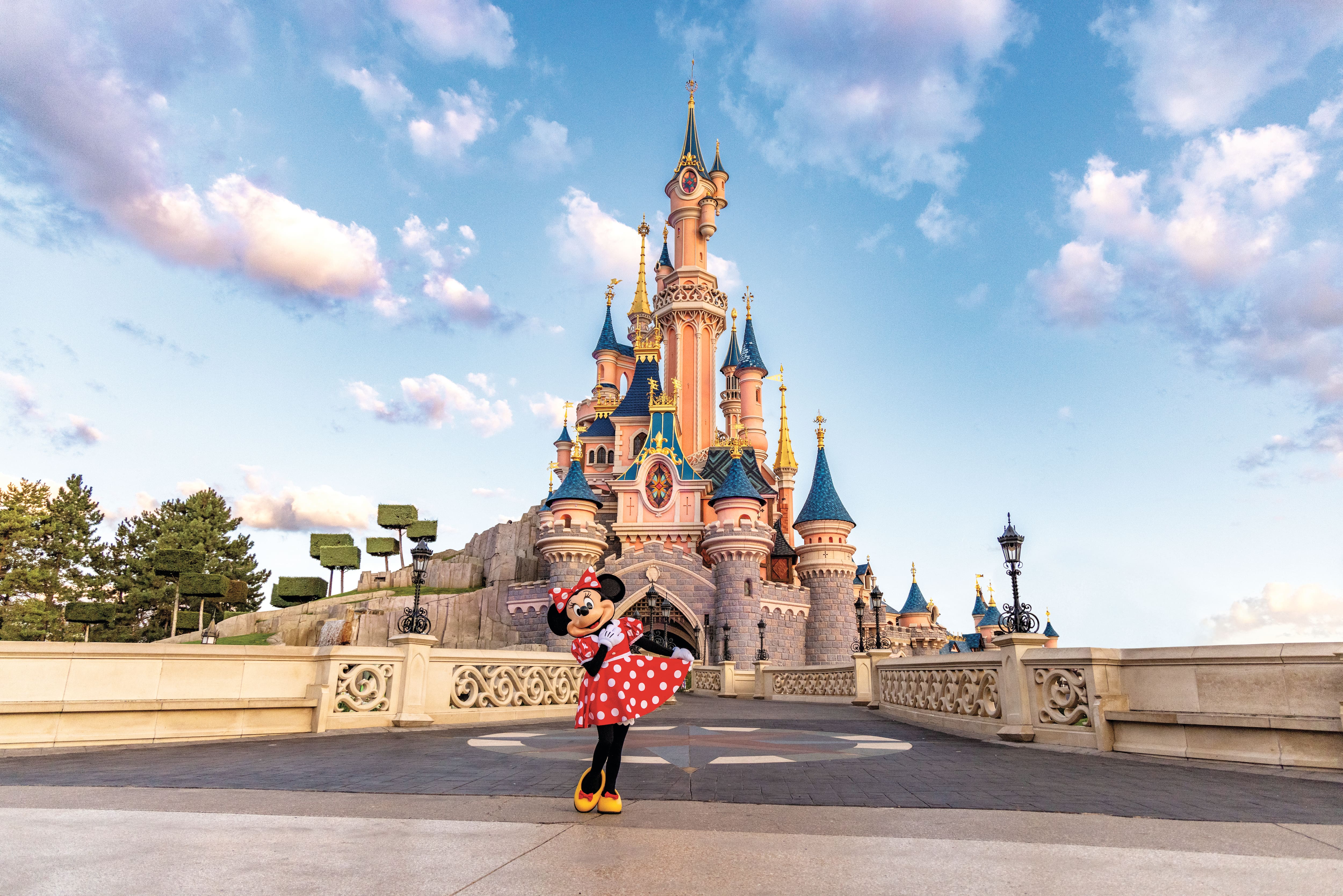 Minnie Mouse in front of the Sleeping Beauty Castle at Disneyland Paris.