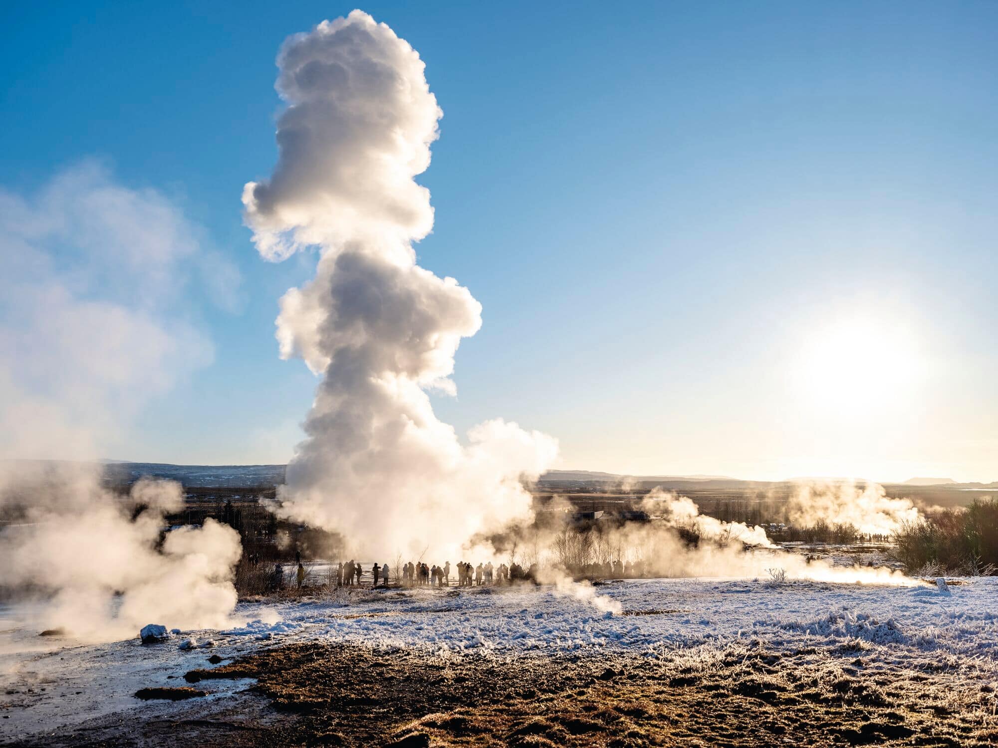 People standing around a geyser in Iceland.
