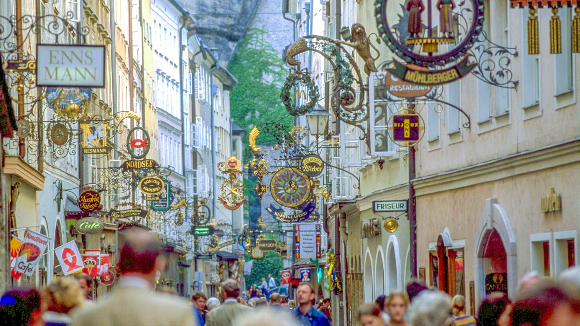 A street in Salzburg with hanging shop signs. 