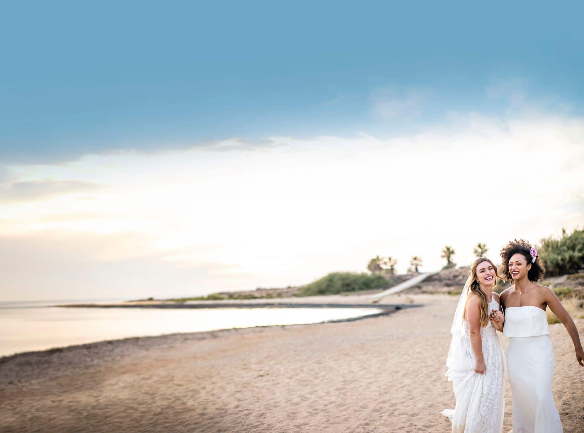 A same-sex wedding couple on a beach.