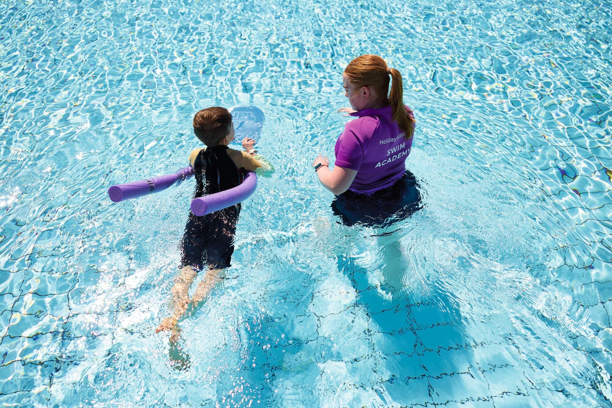 A boy learning to swim with a Holiday Village swim coach.