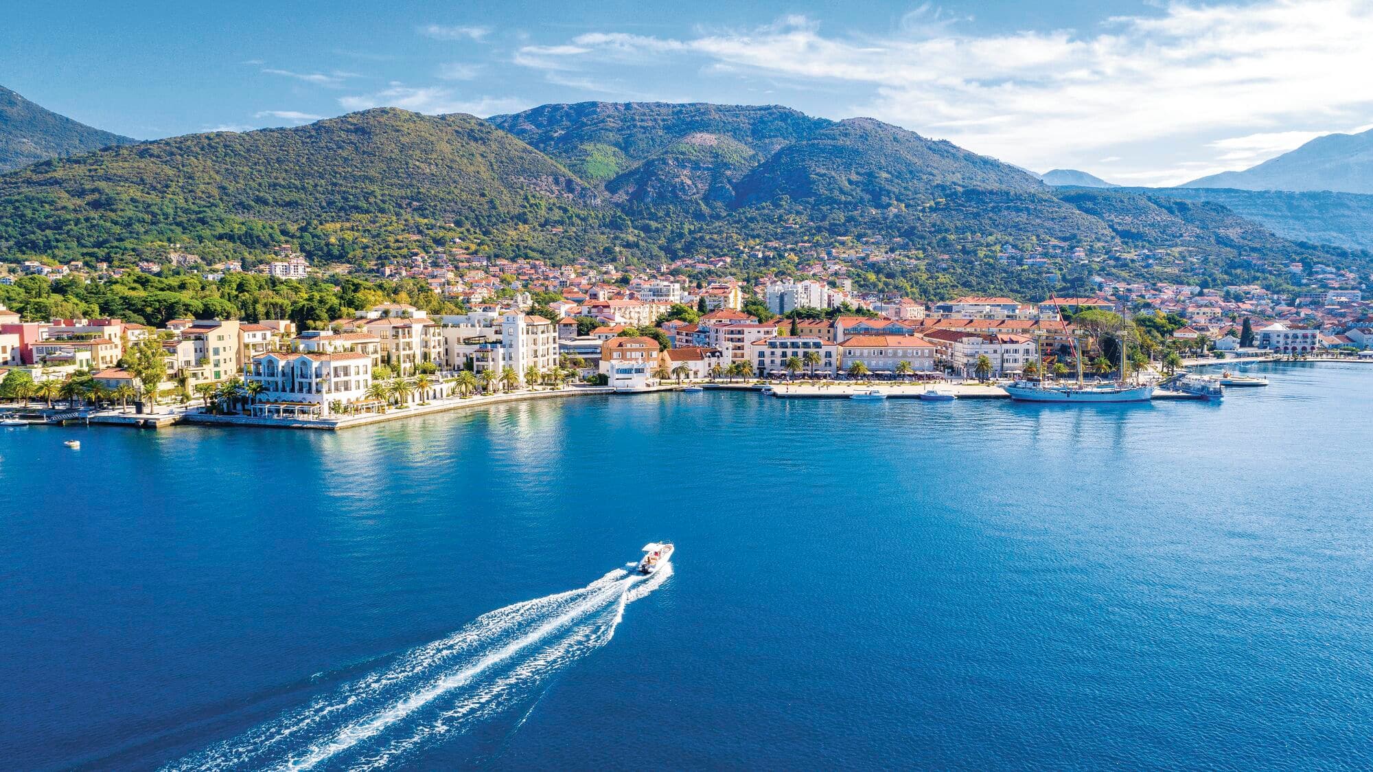 A speedboat sailing towards the coastline of Montenegro.