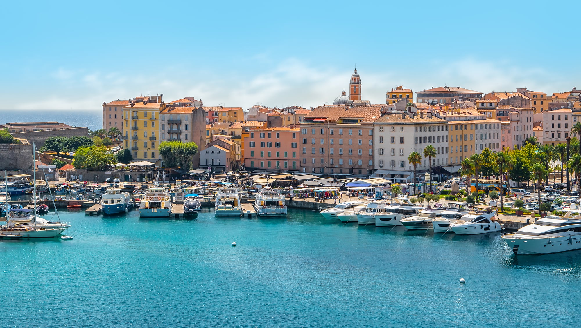 A view of multiple small boats in Ajaccio harbour on a sunny day.