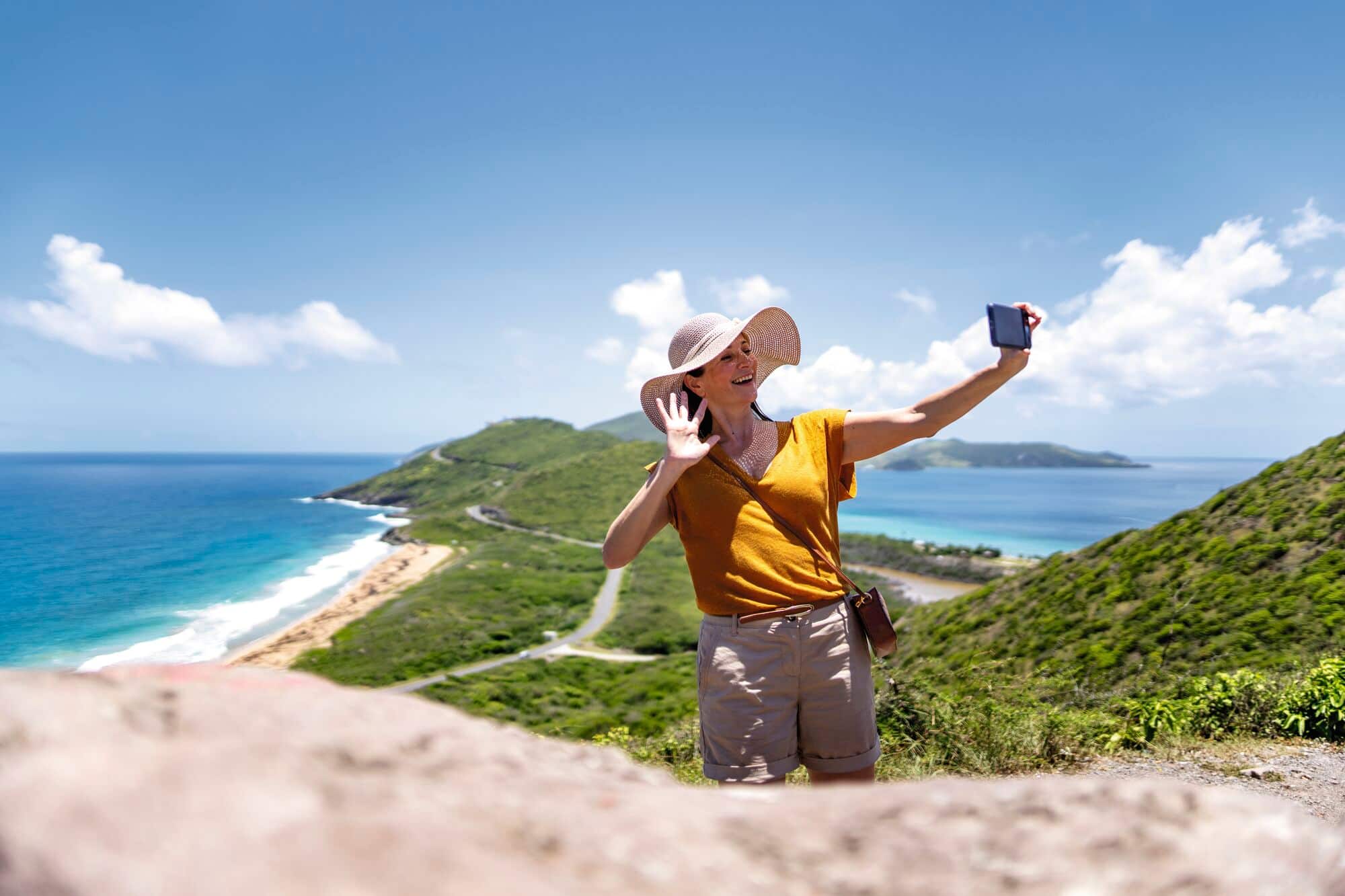 A person taking a selfie in front of a green bay.