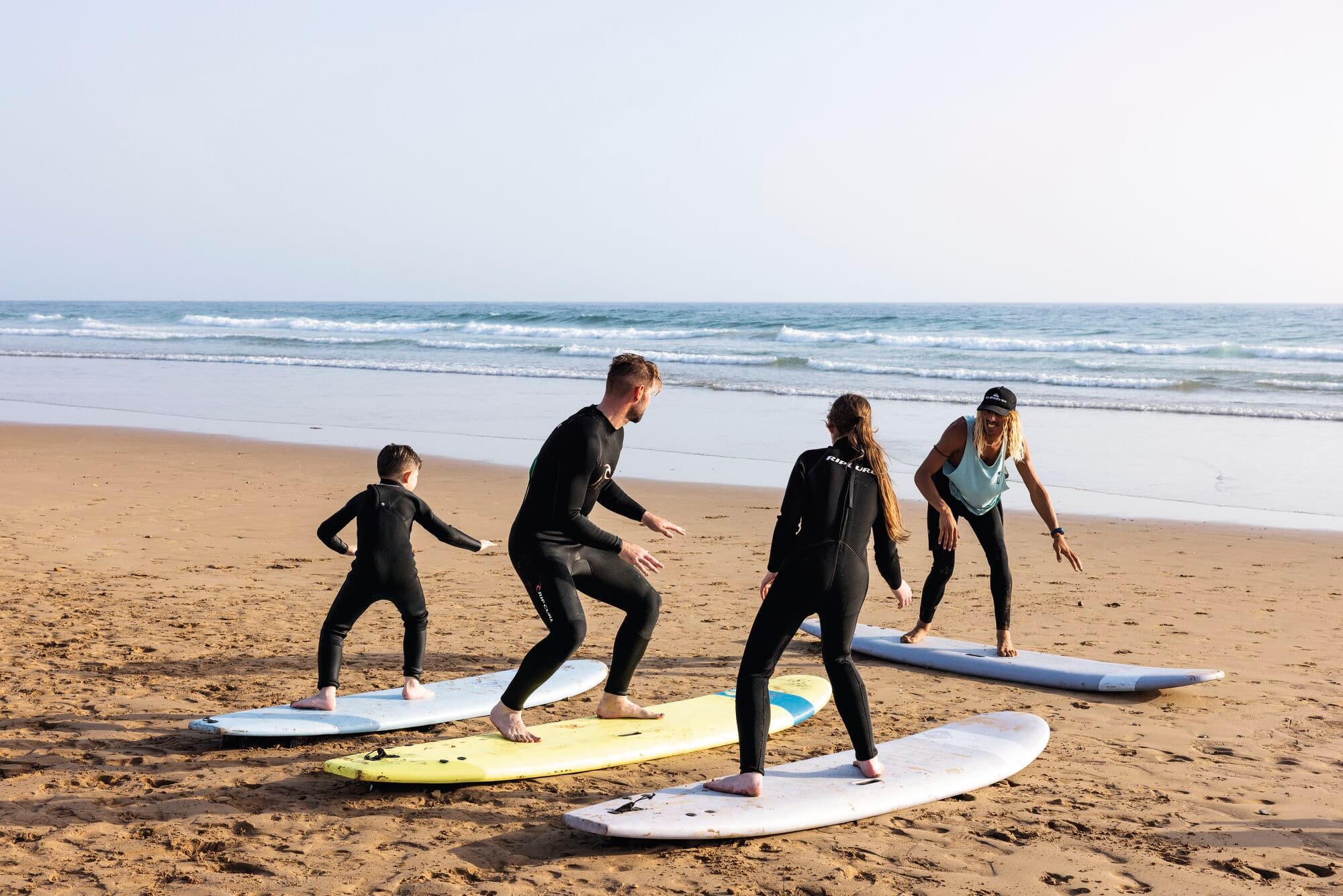 A family having surf lessons on a beach.