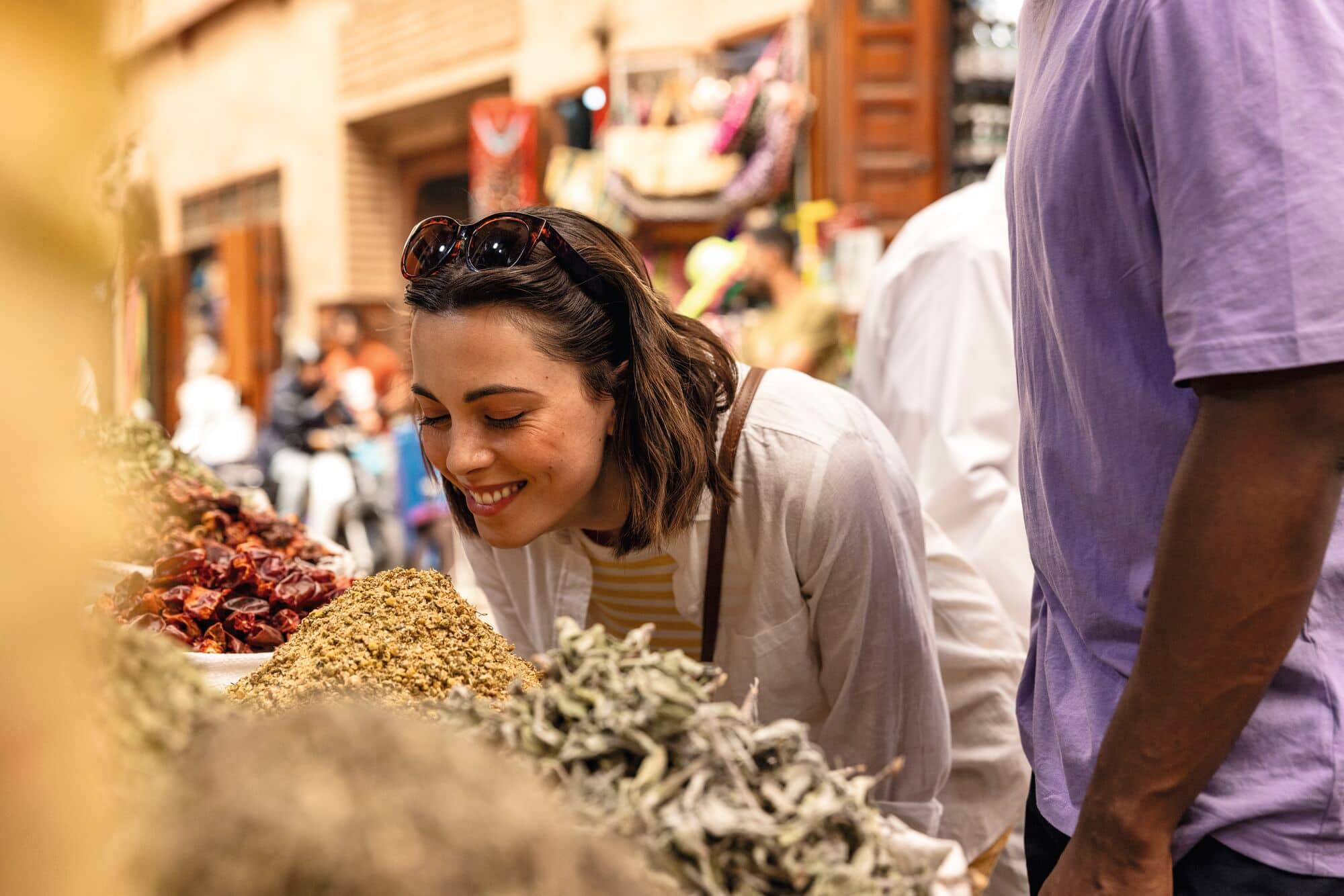 A woman smelling spices in a Souk in Marrakech, Morocco.