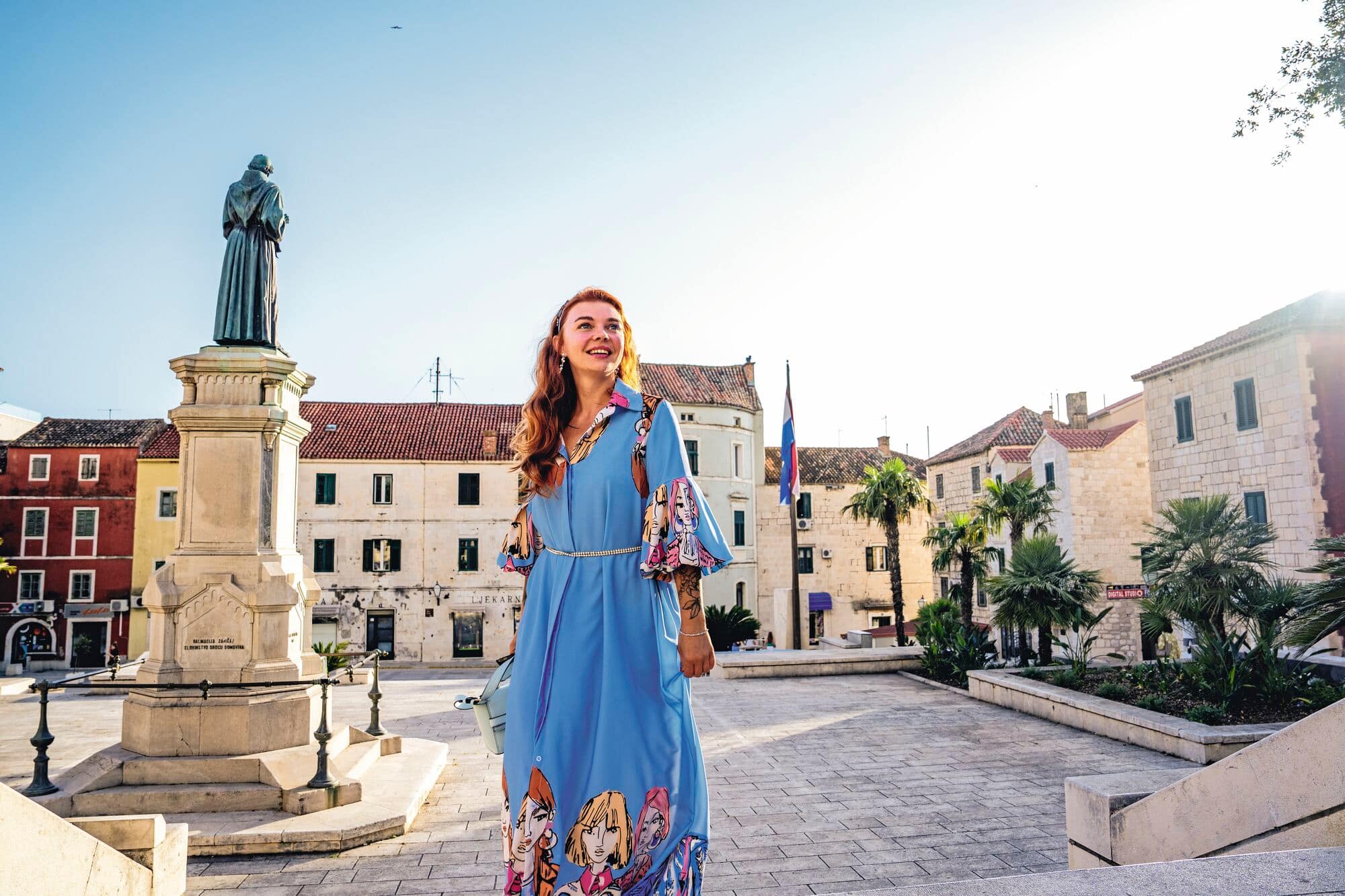 Woman walking through Makarska town square.