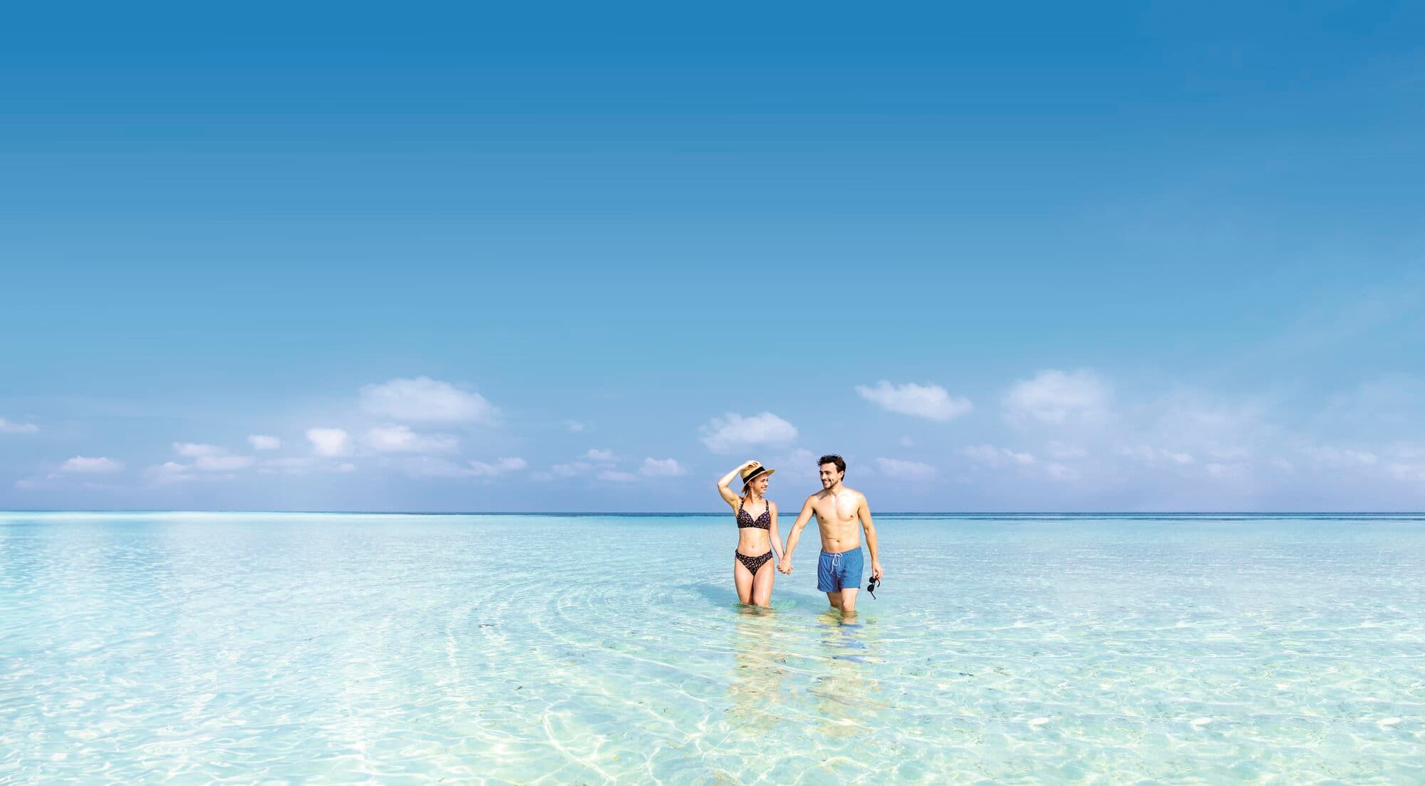 Couple walking together in the sea.