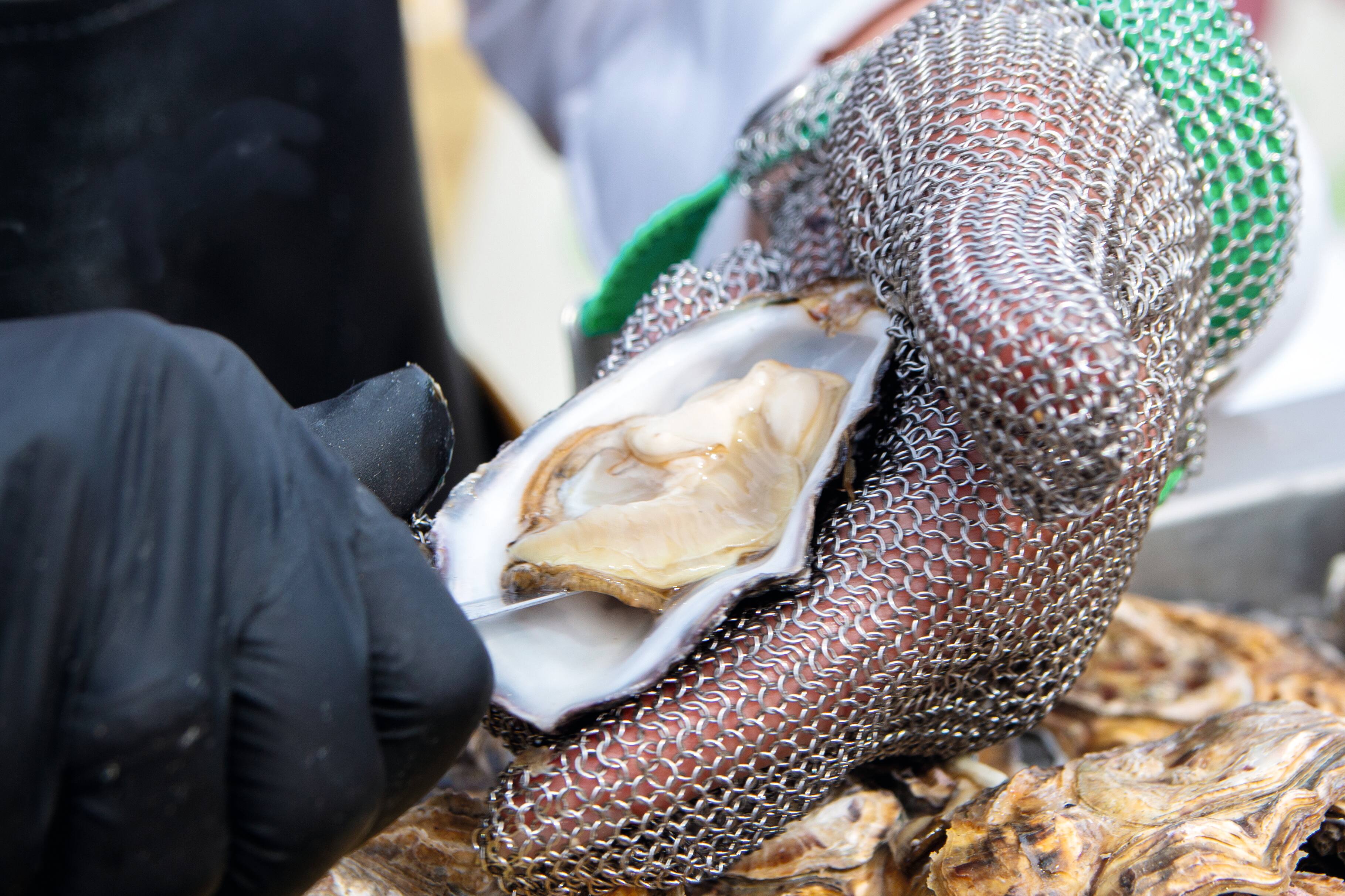 An oyster being removed from its shell.