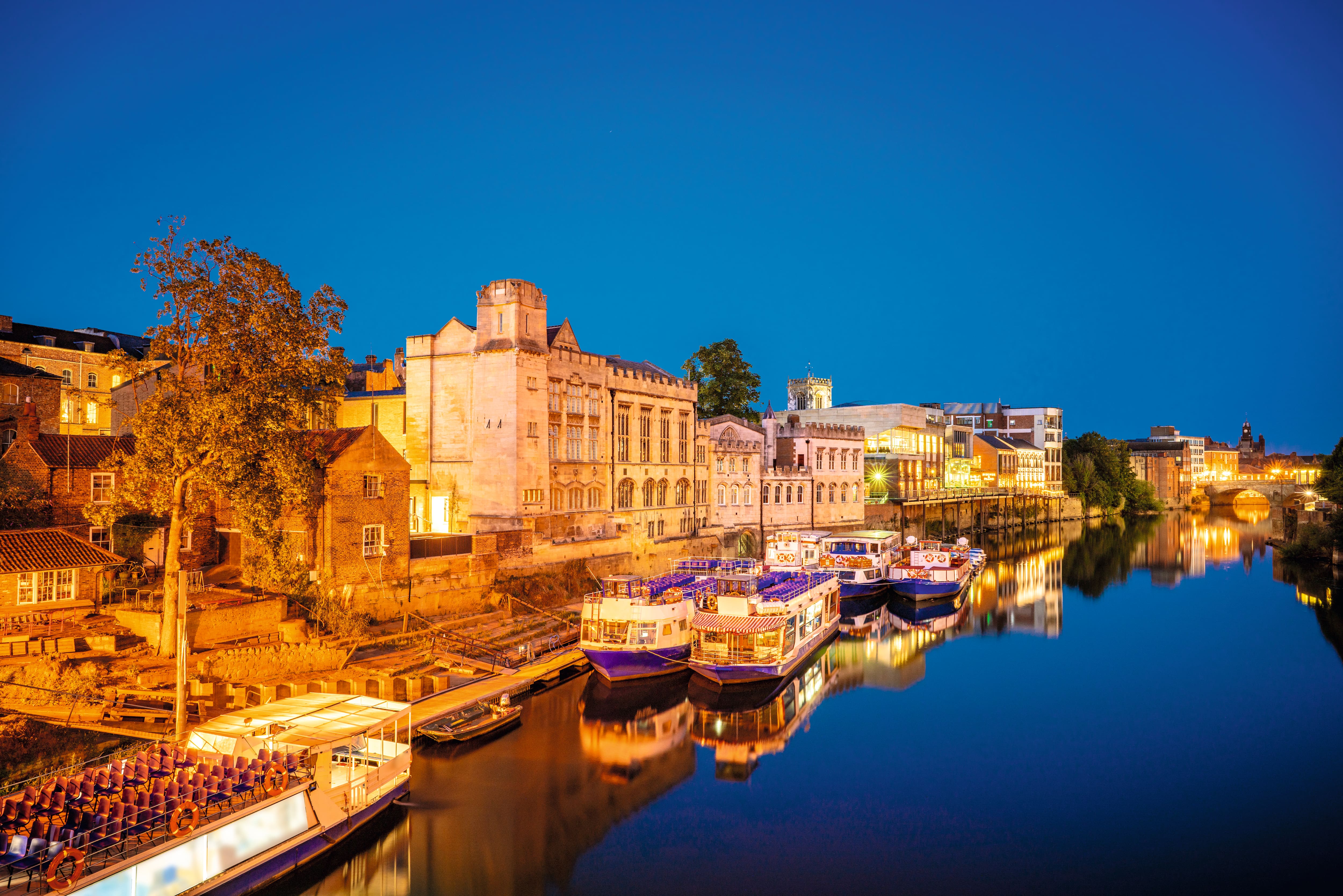 River cruise ships docked at the side of the river at night.