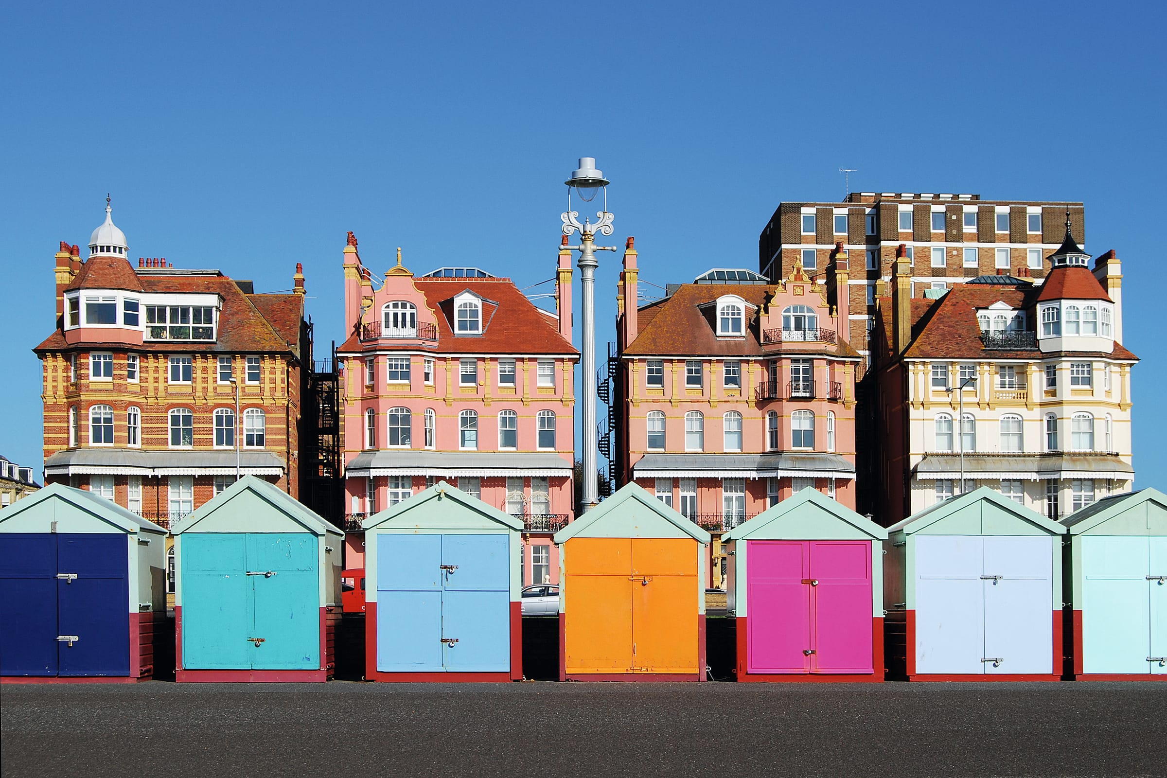Row of brightly coloured beach huts on Brighton seafront.