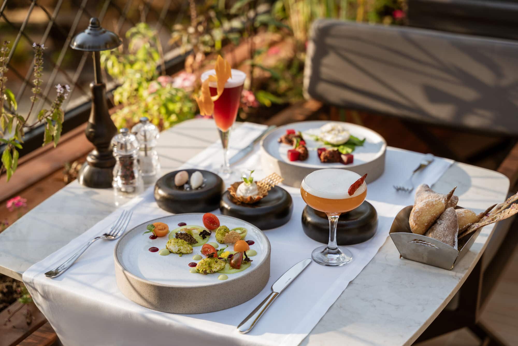 Plates of food and cocktails arranged on a table.
