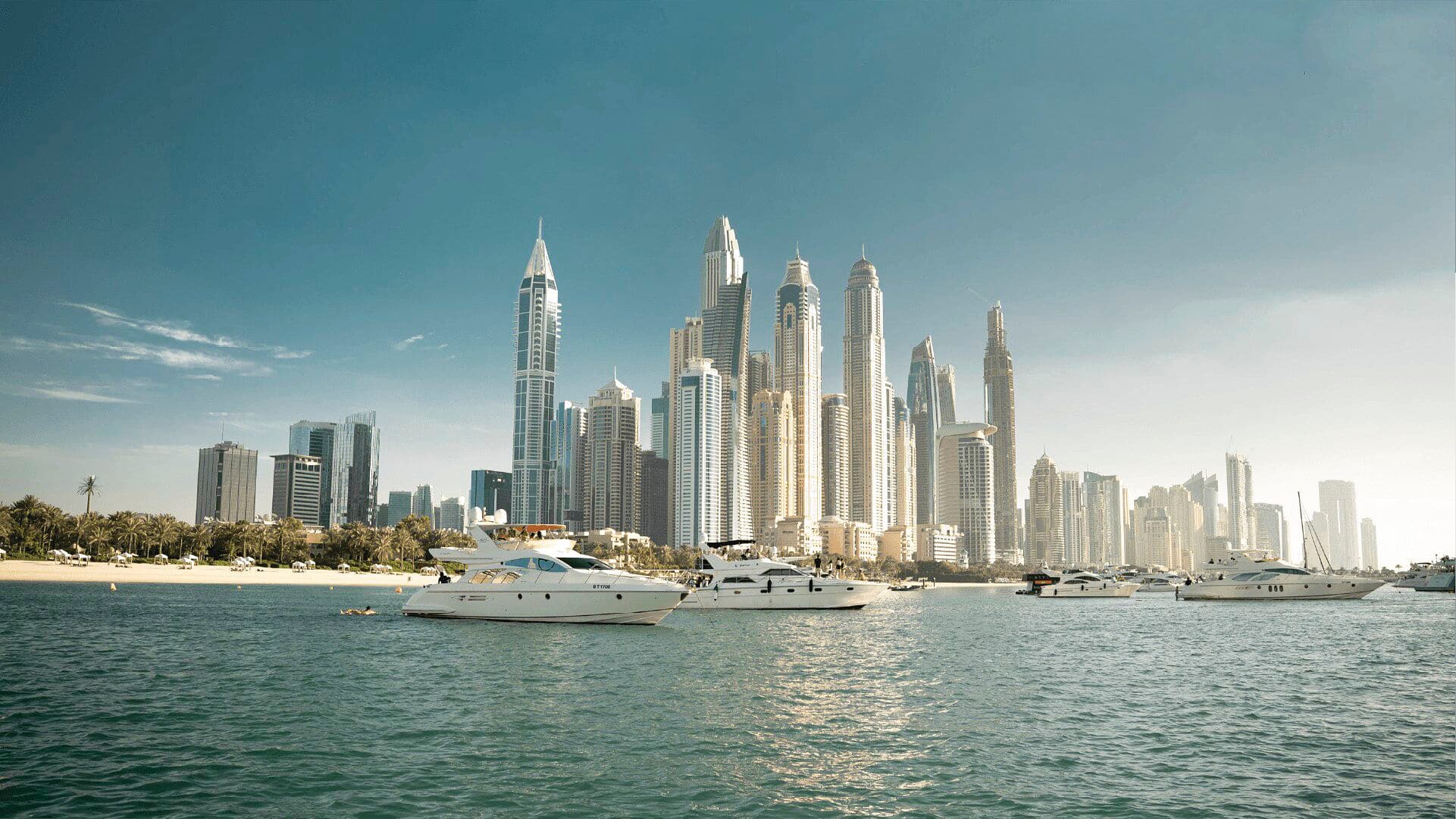 A pair of private yachts look on to the skyline of Dubai.