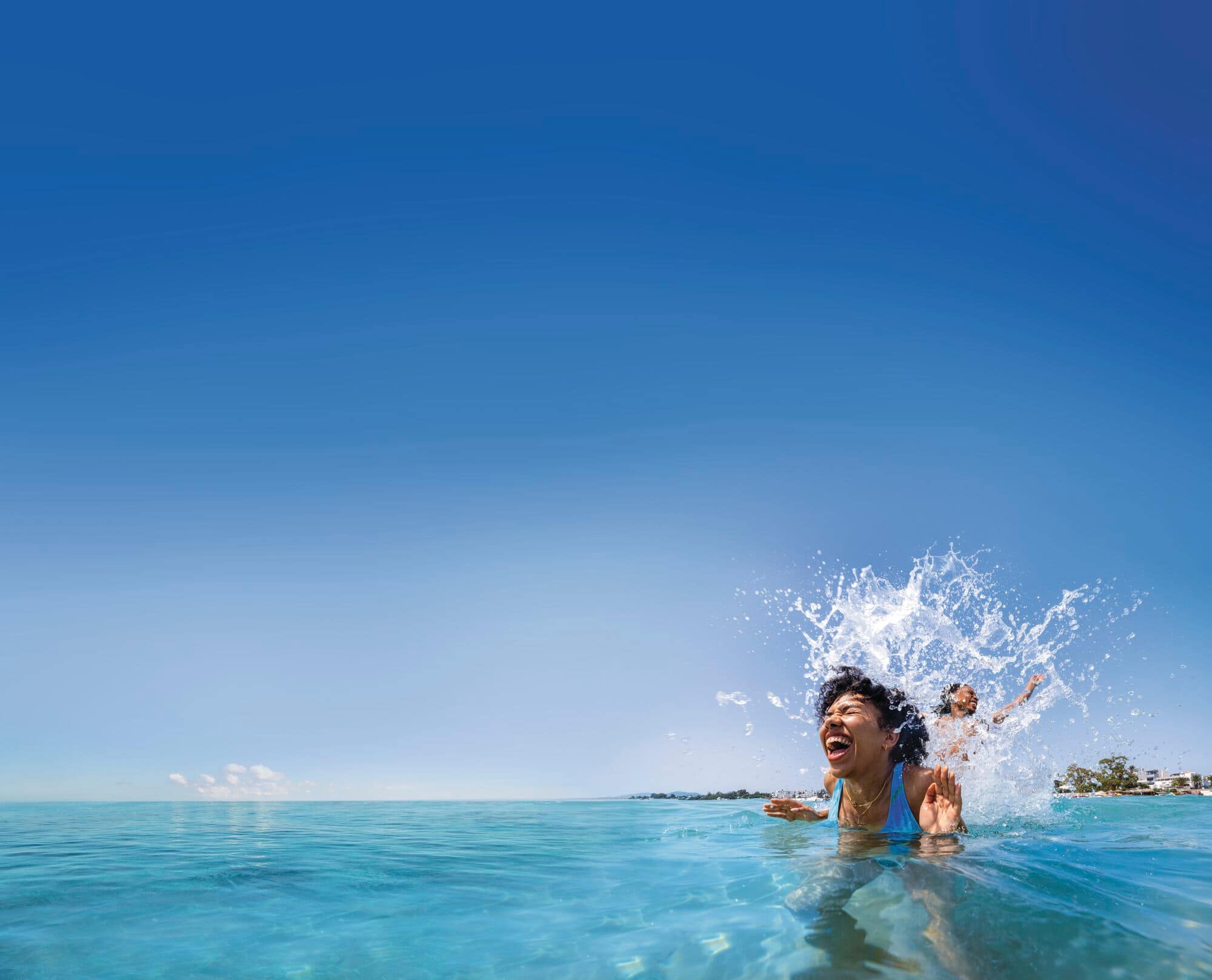 A couple jumping and splashing in a pool