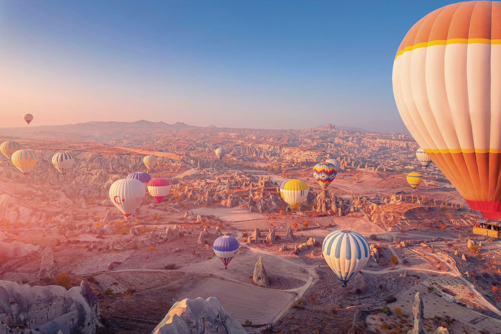 A hot air balloon above deep canyons in Cappadocia, Turkey.