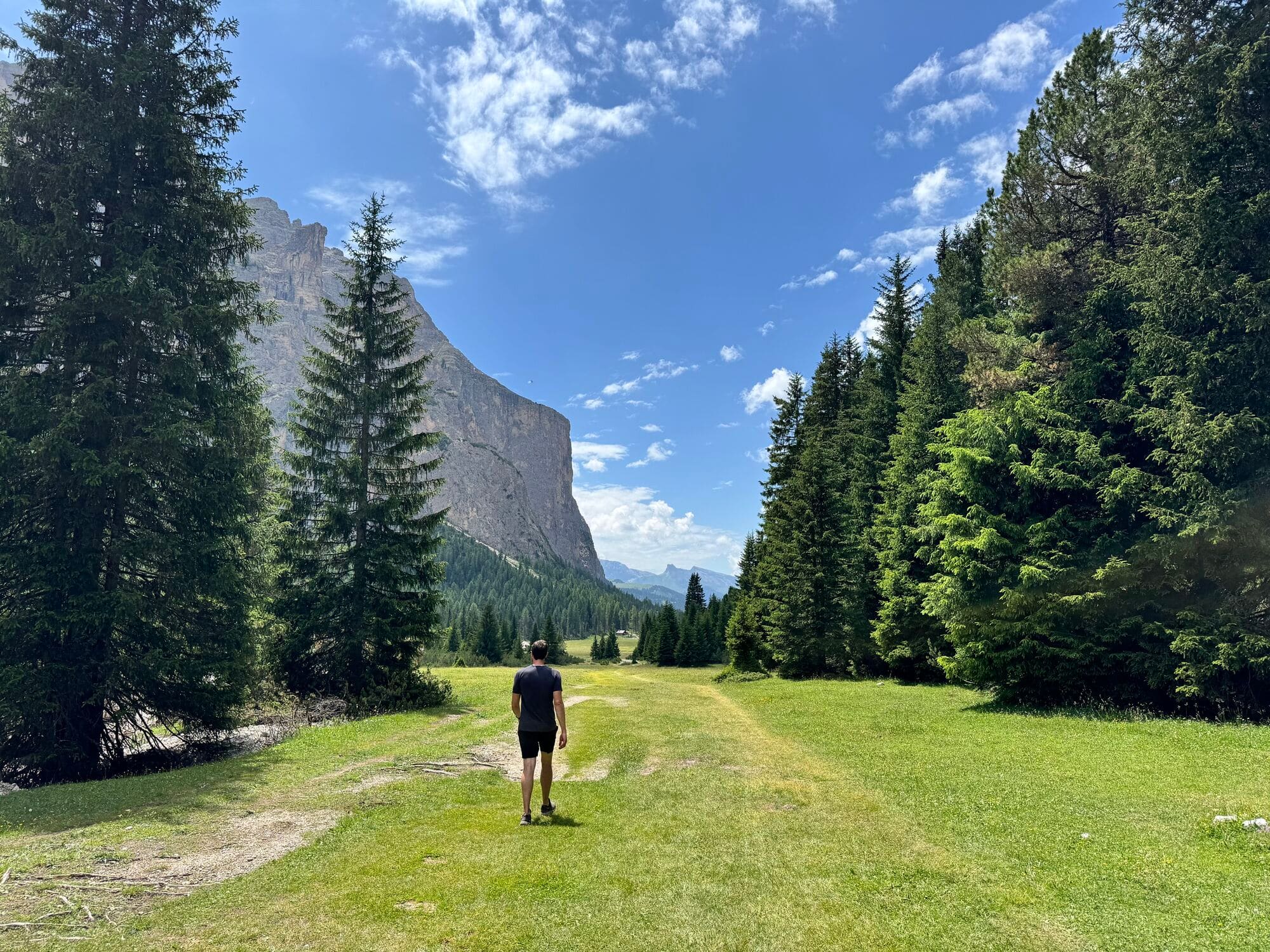 A man walking through a grassy valley.