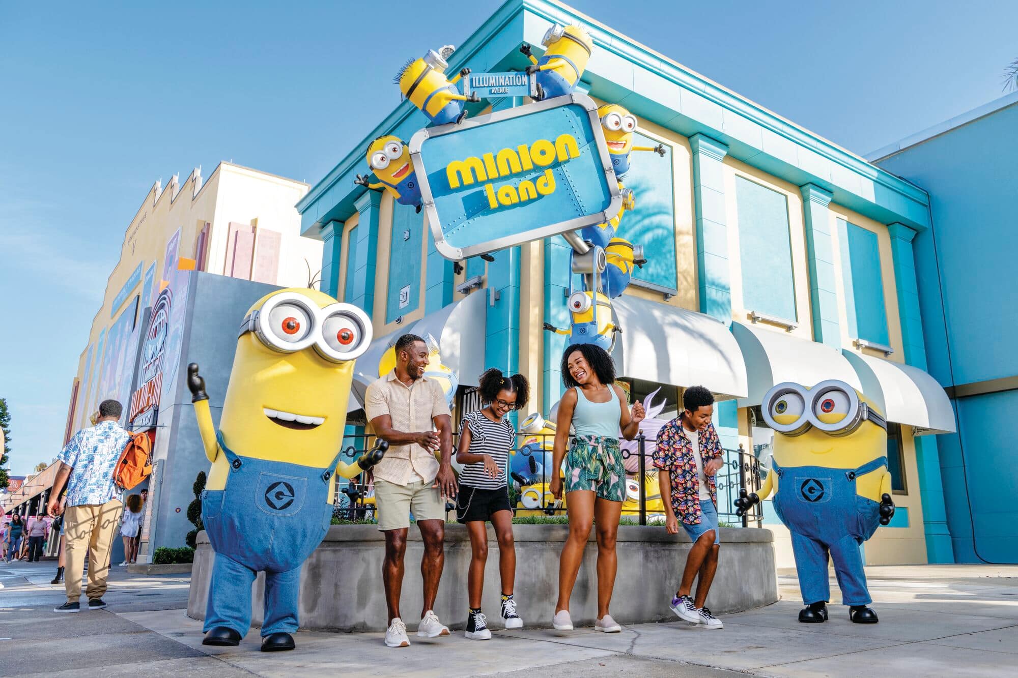 A family of four pose with two large Minions characters.