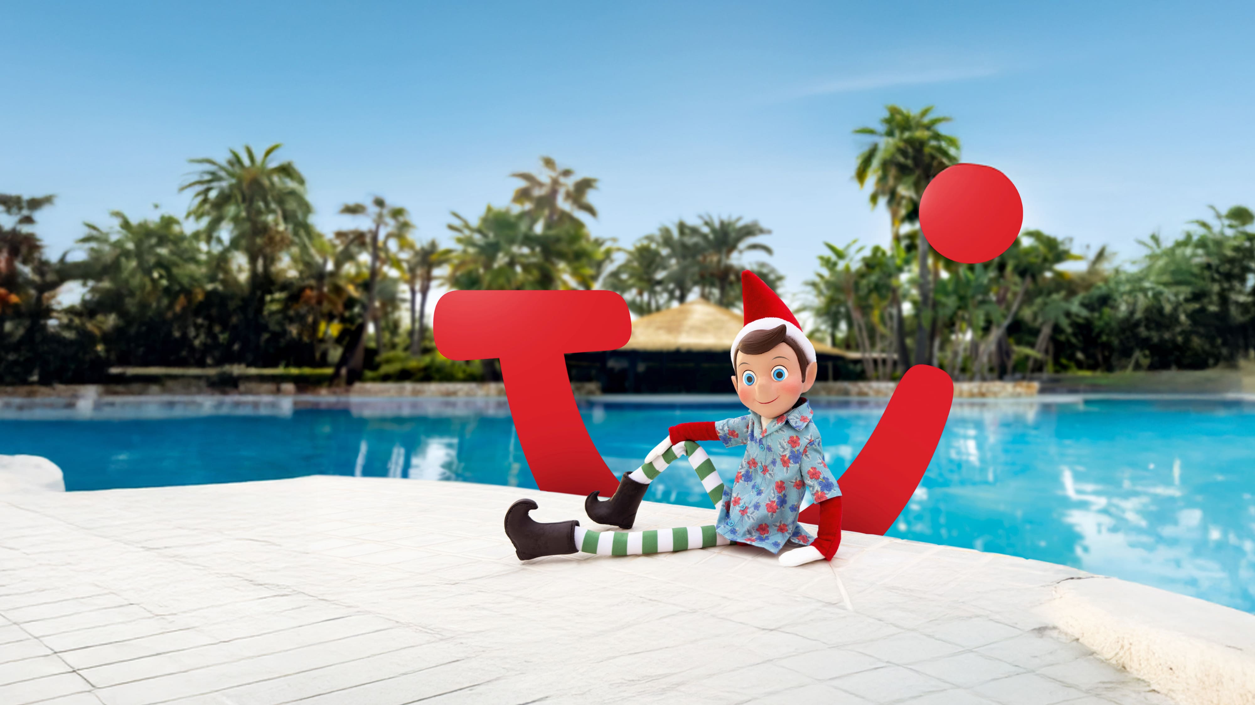A toy elf in a relaxed sitting position at the side of a pool