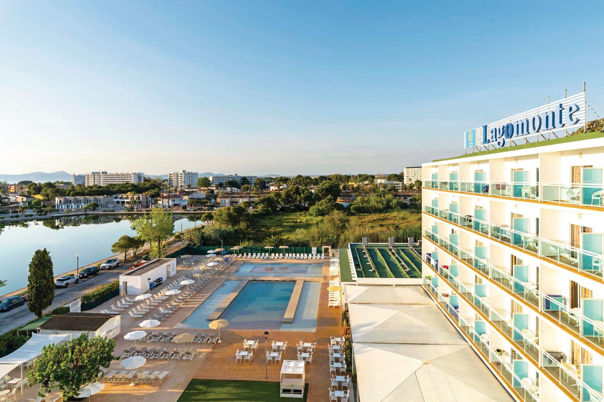 Aerial view of hotel building, pool and surrounding area.