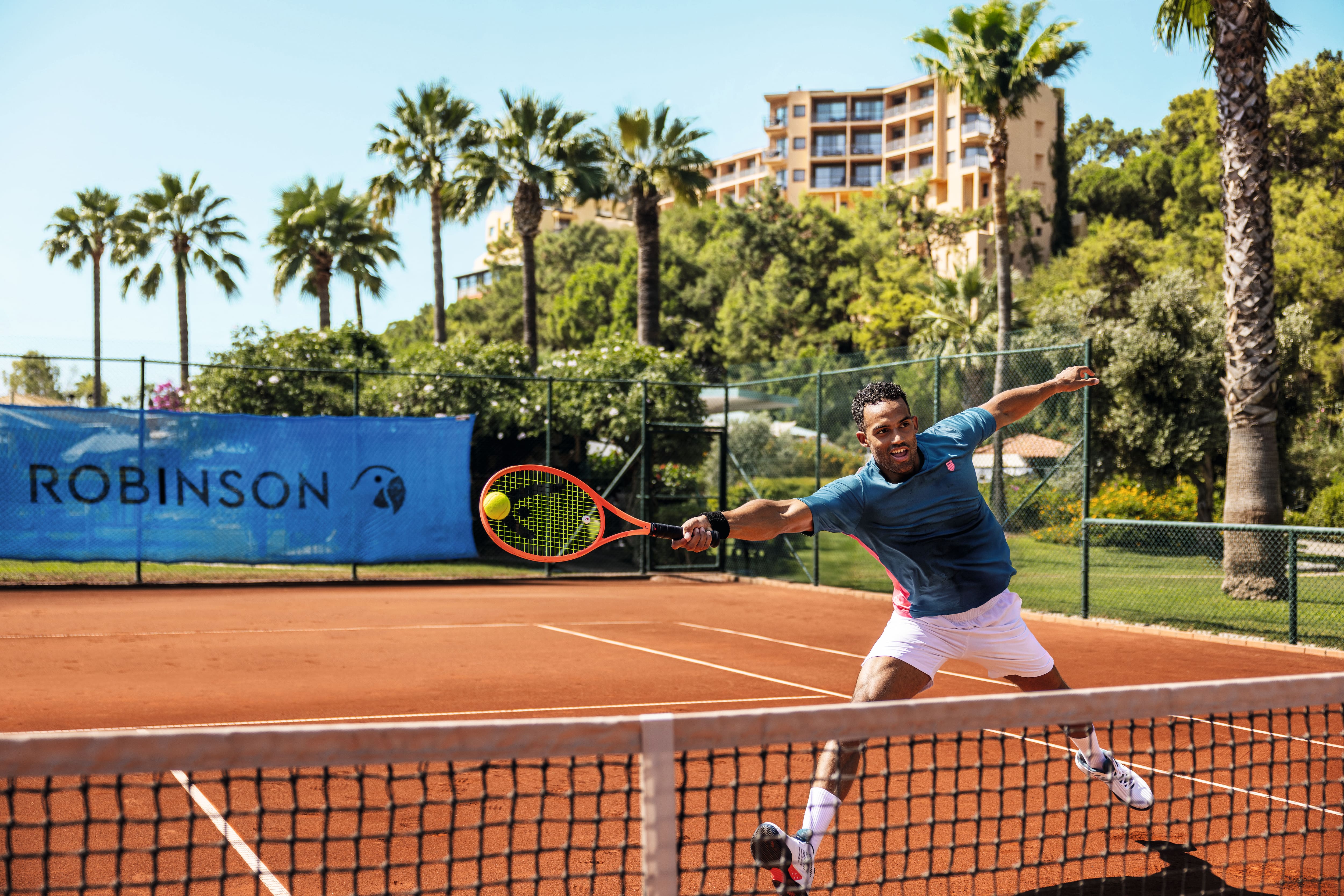 A man lunging for a shot on a tennis court.