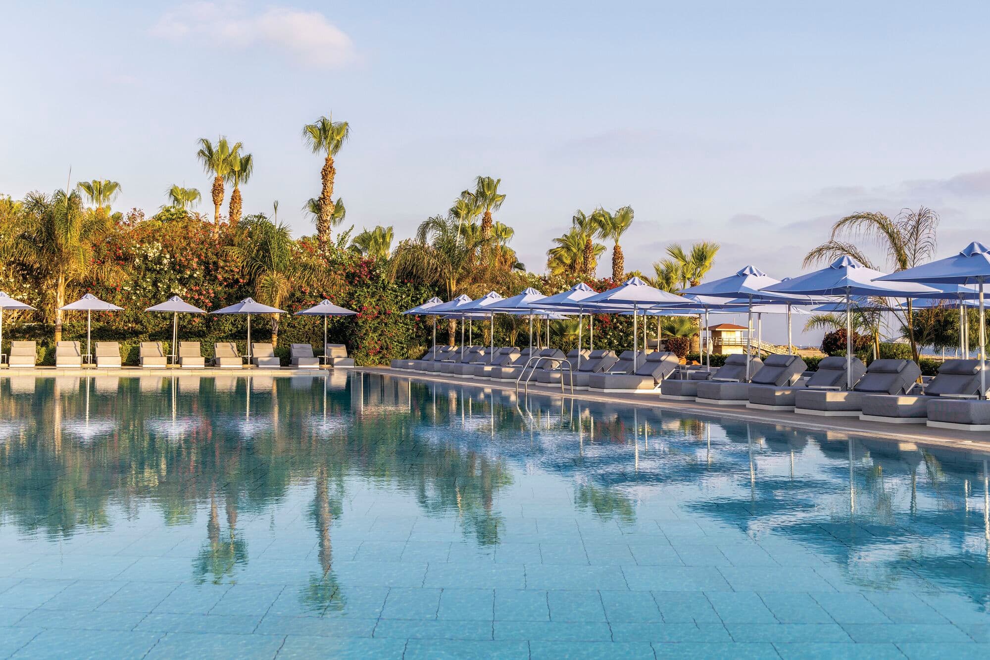 Sunloungers and parasols by a hotel pool.