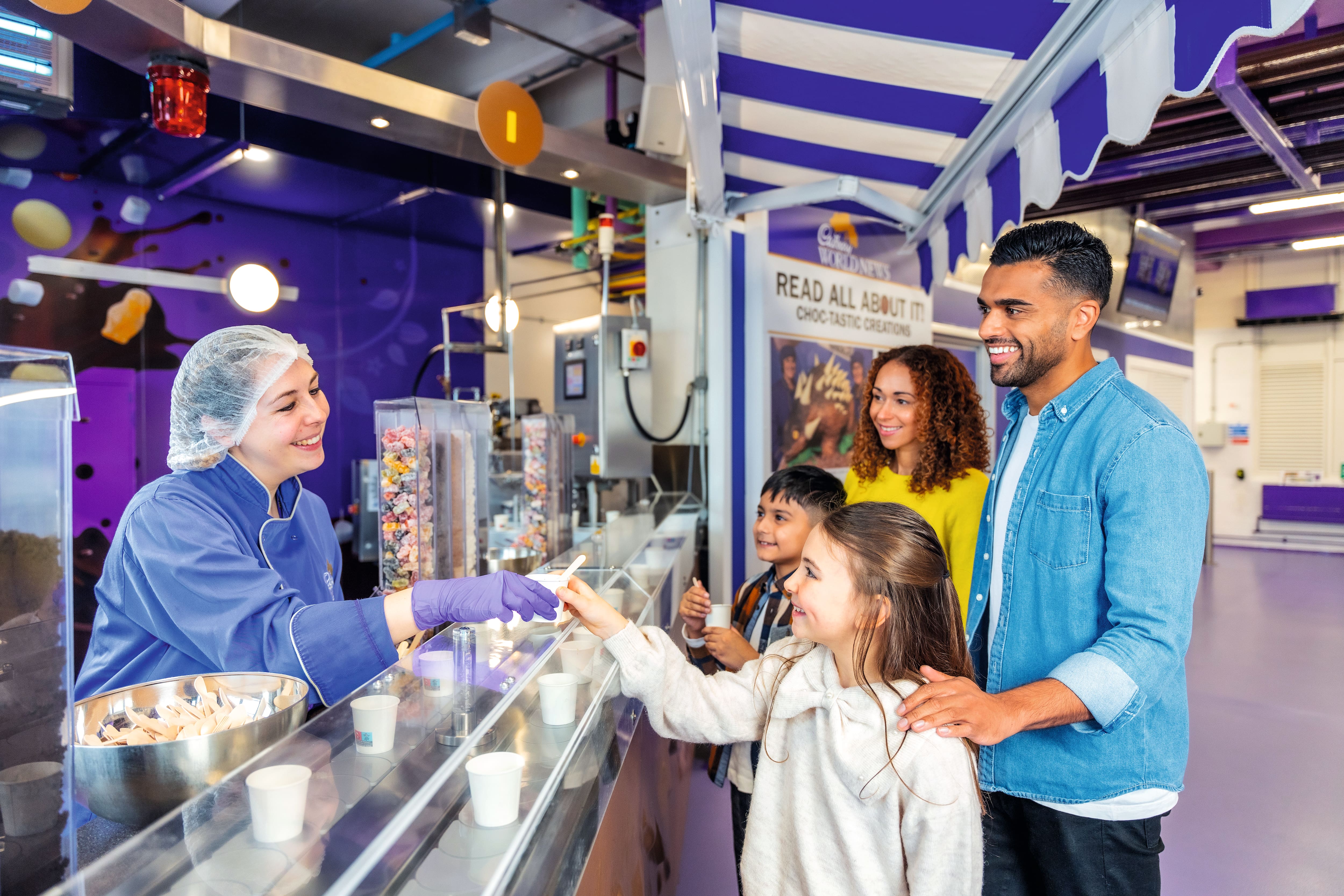Family being served chocolate by Cadbury’s worker.