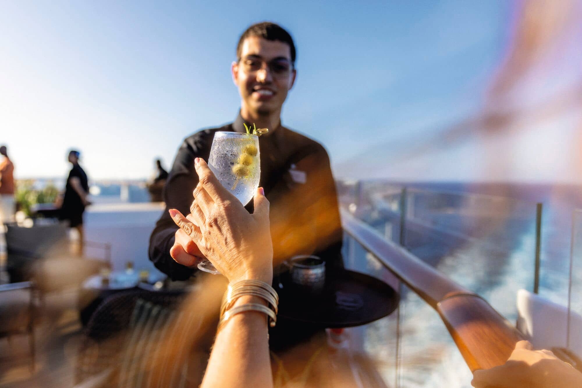 A customer receiving a drink from a waiter.
