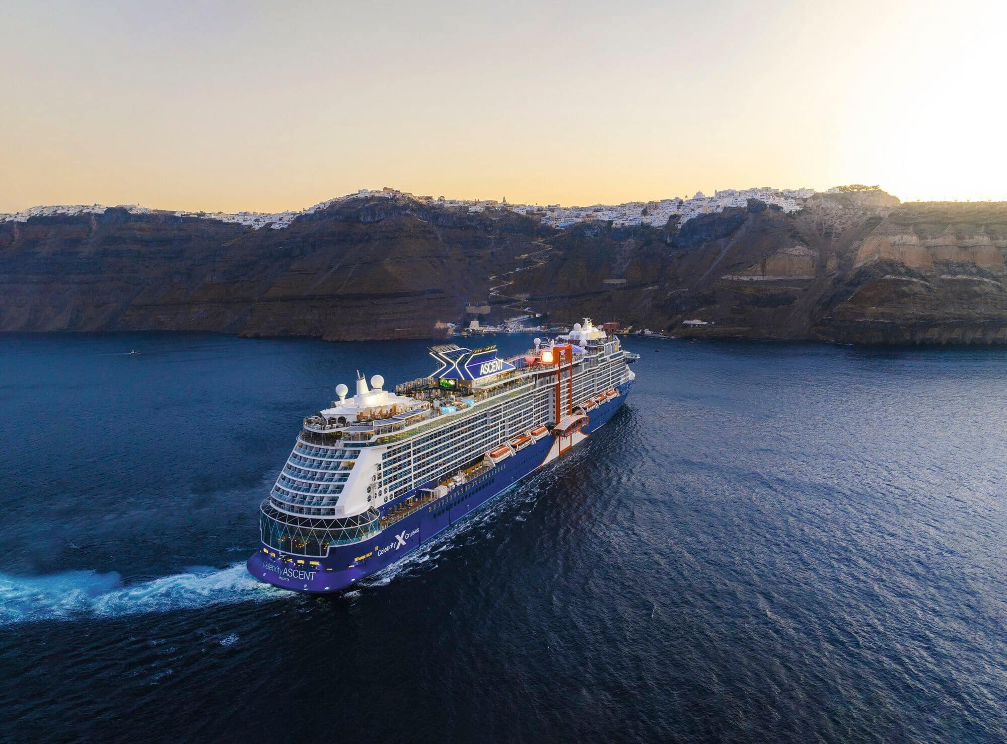 A cruise ship leaving a dock.
