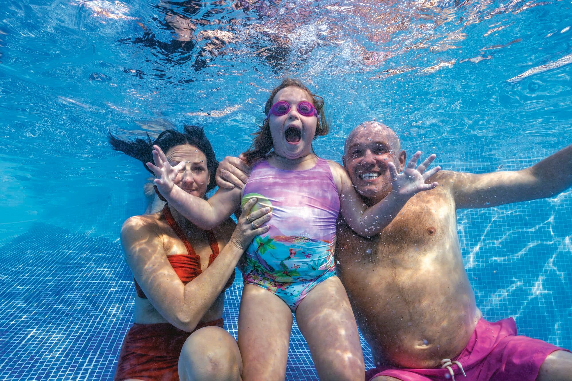 A family posing underwater.