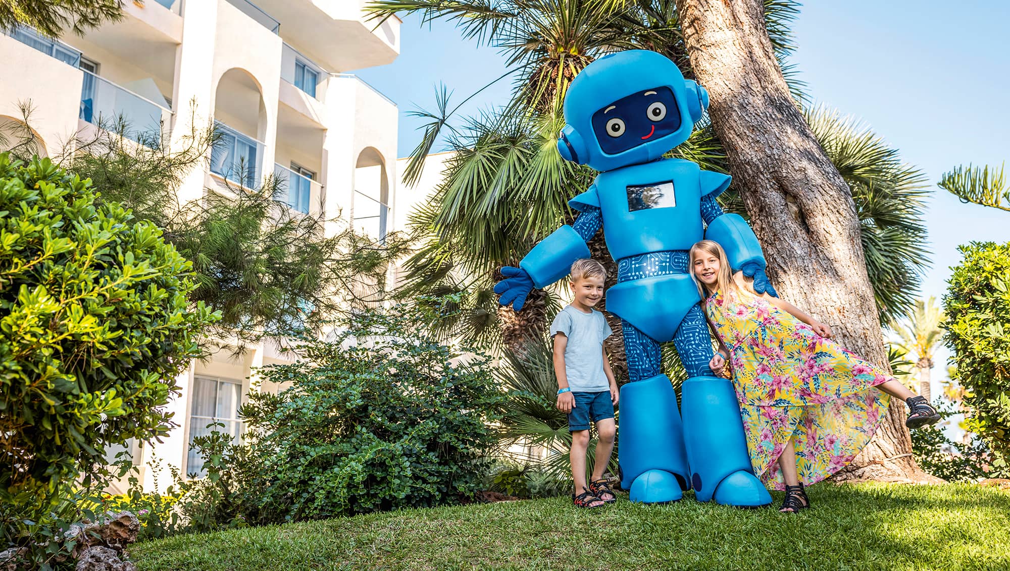 Two children with a robot mascot.