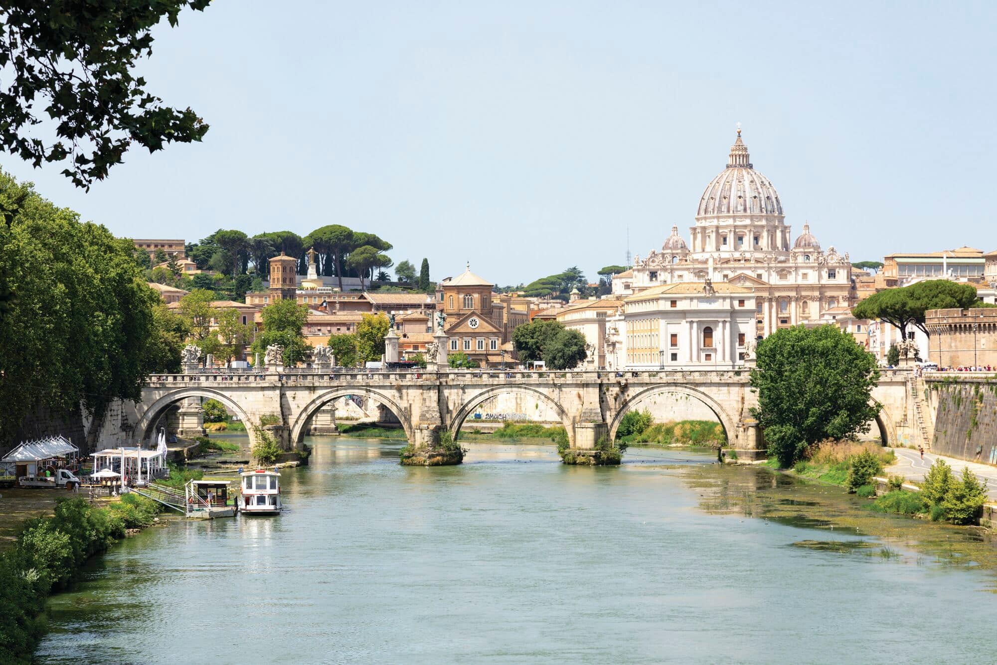 A view of Ponte Sant'Angelo bridge and St. Peter's Basilica from Tiber River in Rome.