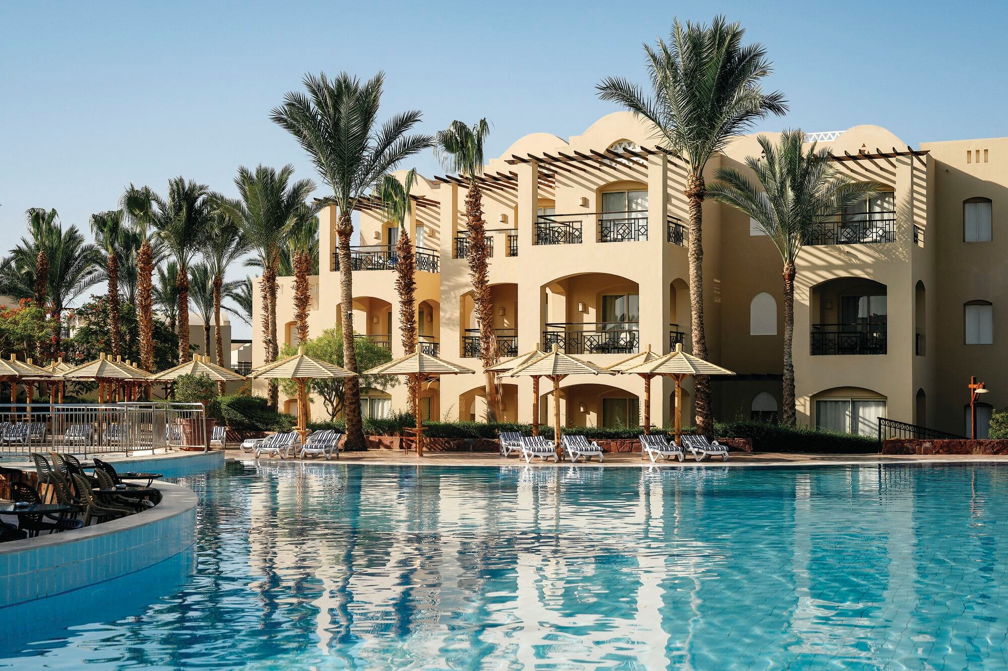 A swimming pool in front of the hotel exterior.