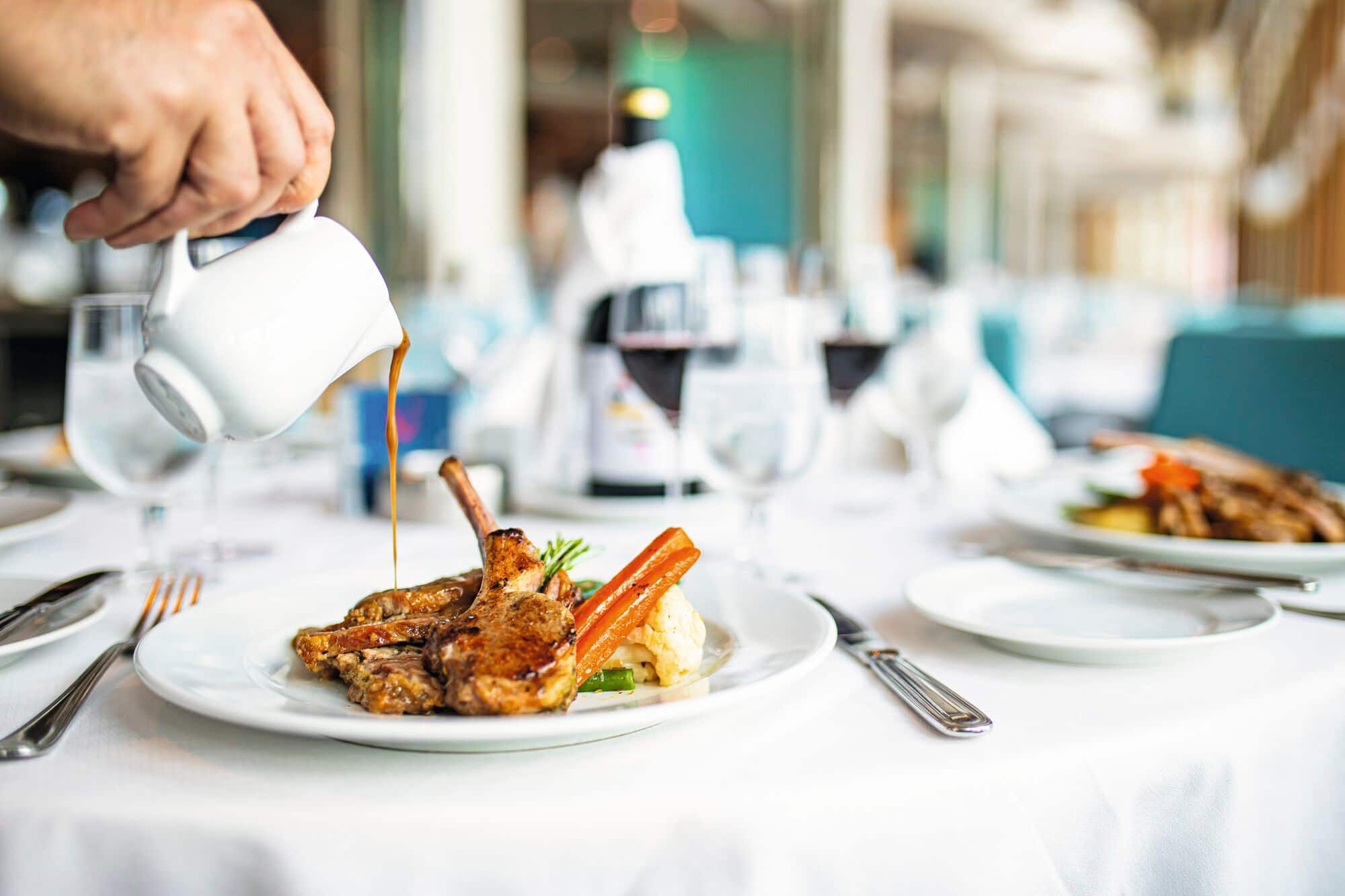 A server pouring gravy over an Easter lunch.