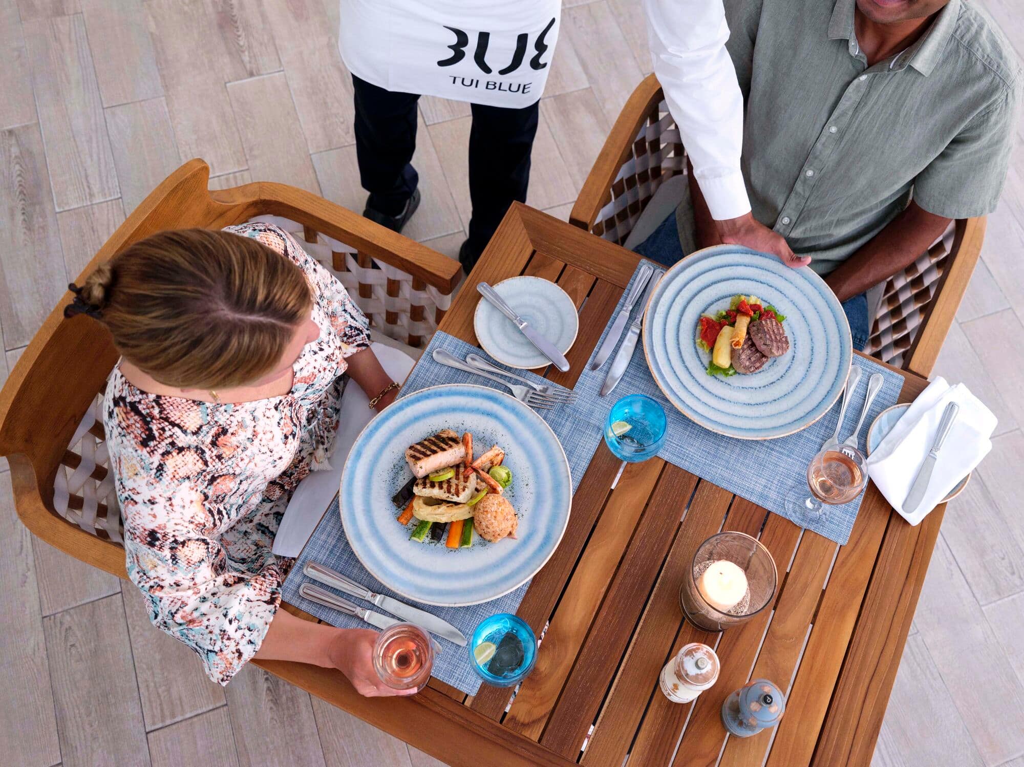 A couple are served plates of food at El Sabbar Beach Restaurant, TUI Blue Samaya.