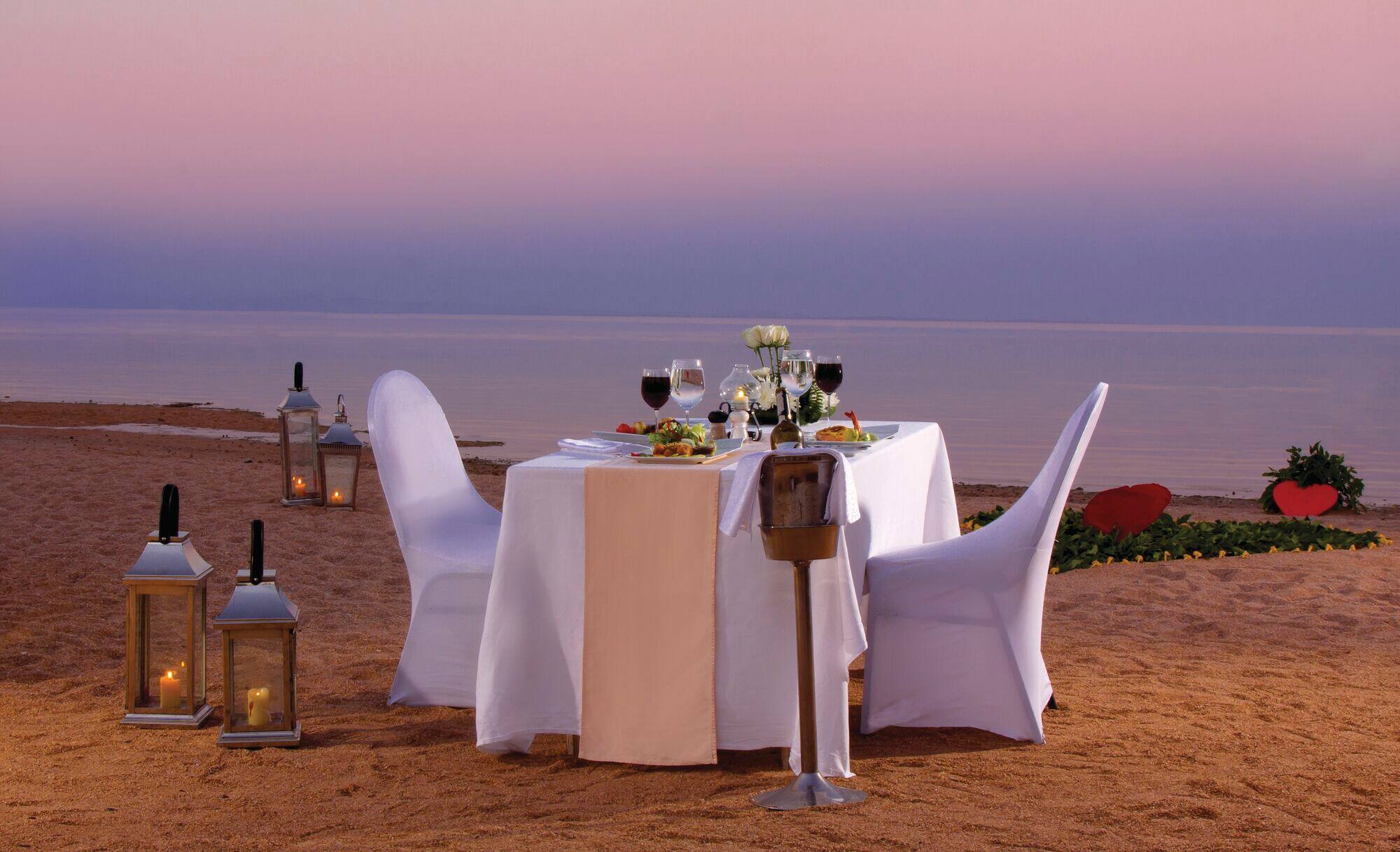 A private table for the happy couple awaits on the sand at sunset.