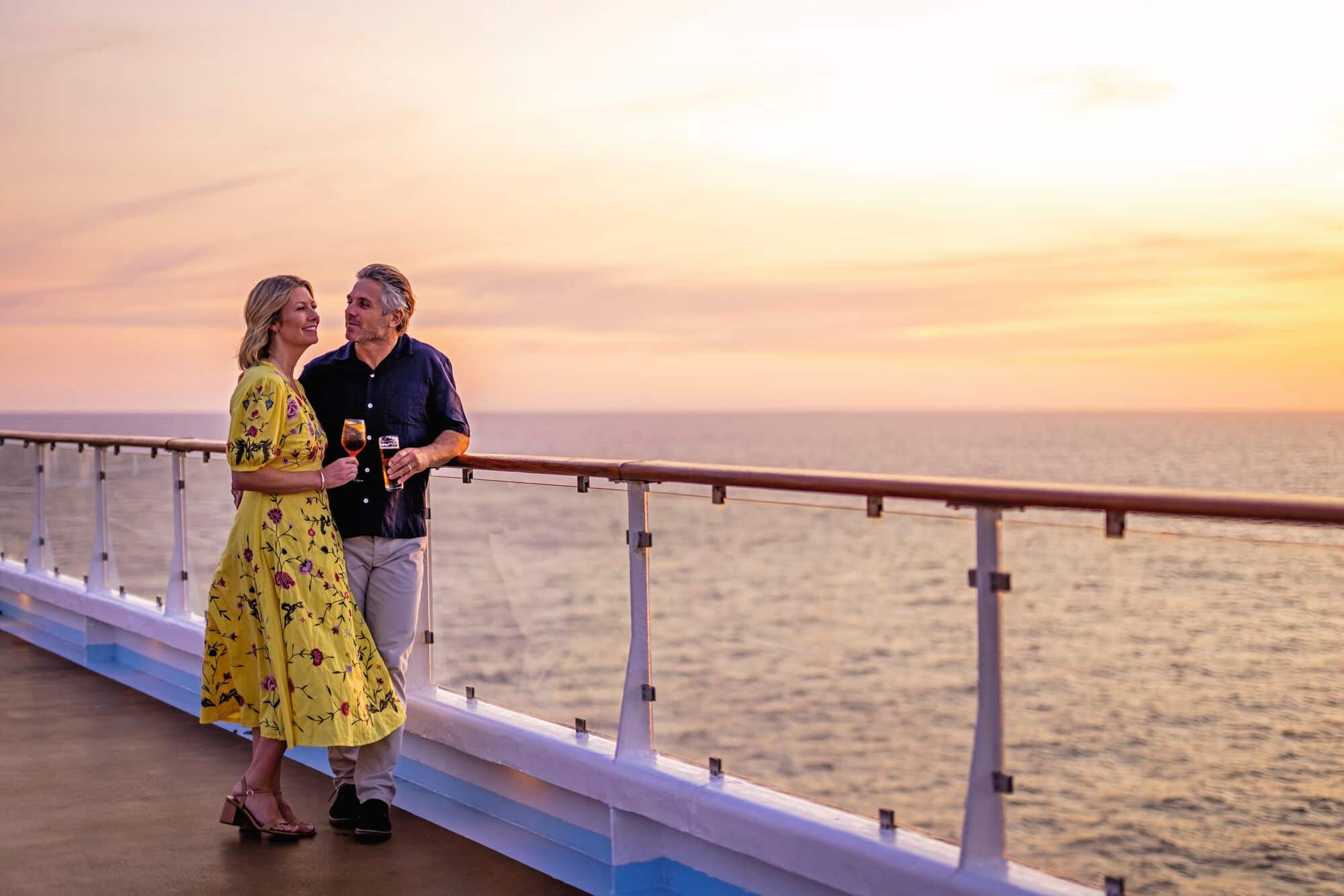 A couple on the top deck at sunset.