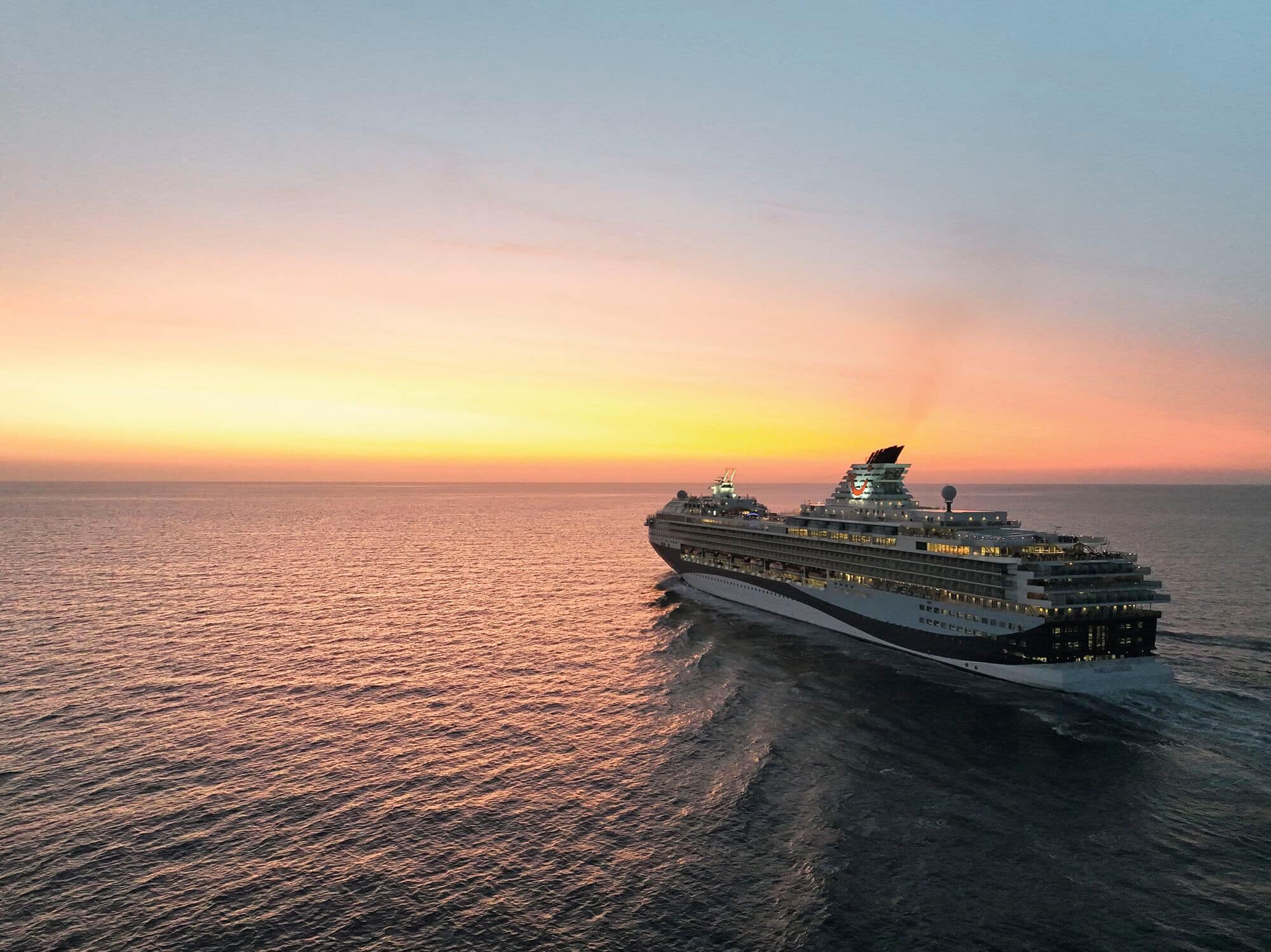 A Marella ship at sea during sunset.