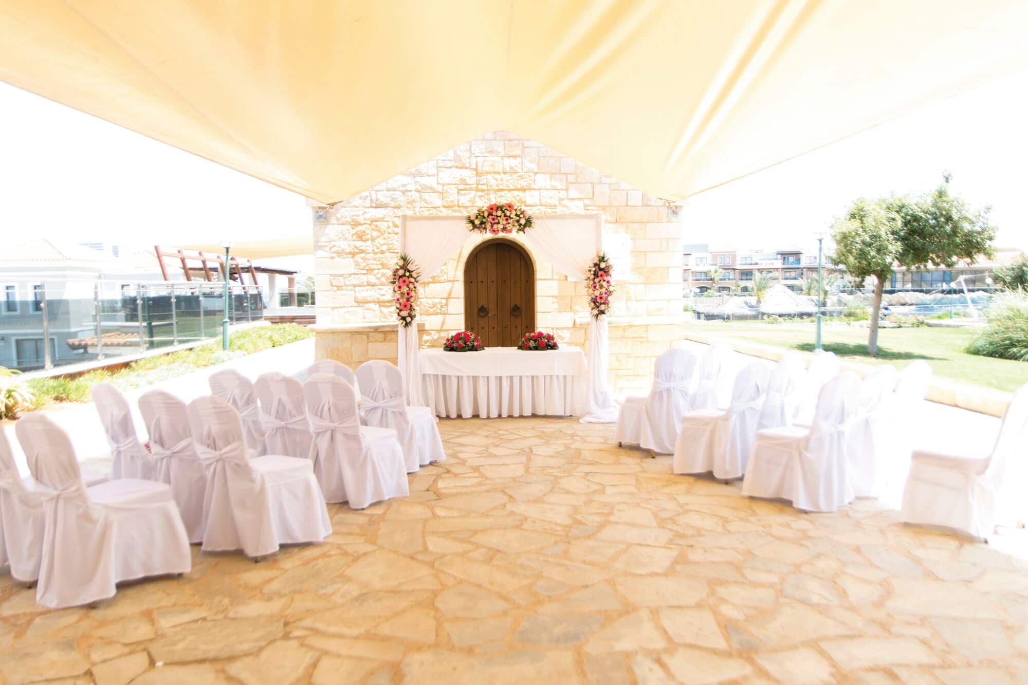 An intimate wedding ceremony set-up in front of a stone chapel.