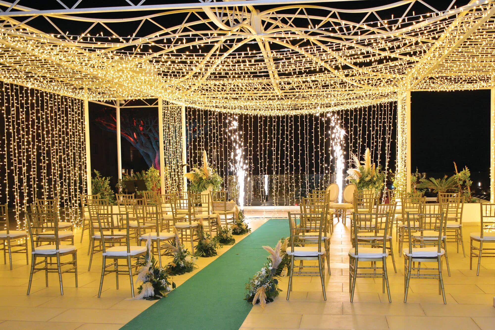 A wedding ceremony set-up surrounded by white fairy lights. 