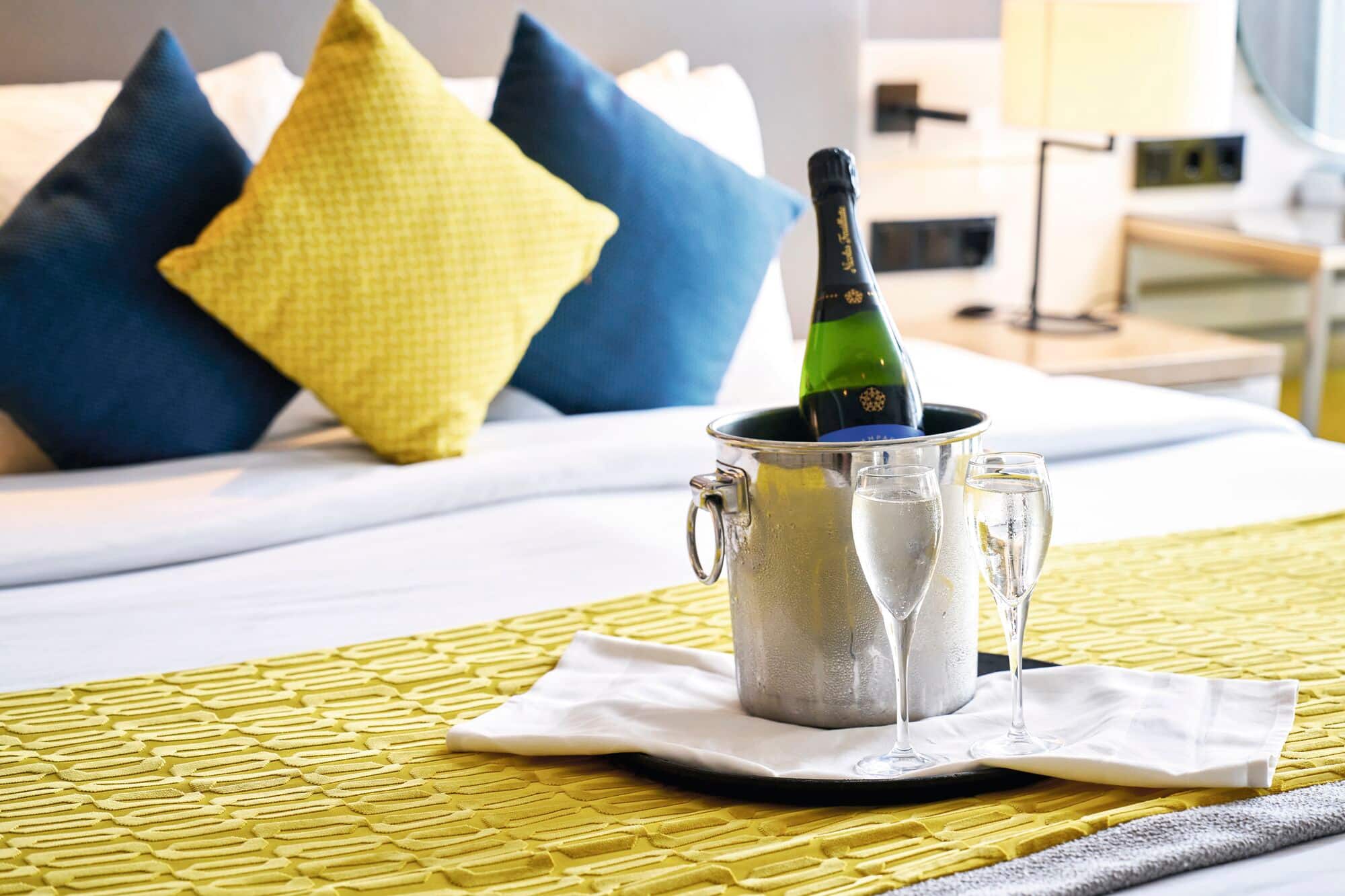 A champagne tray on a bed.