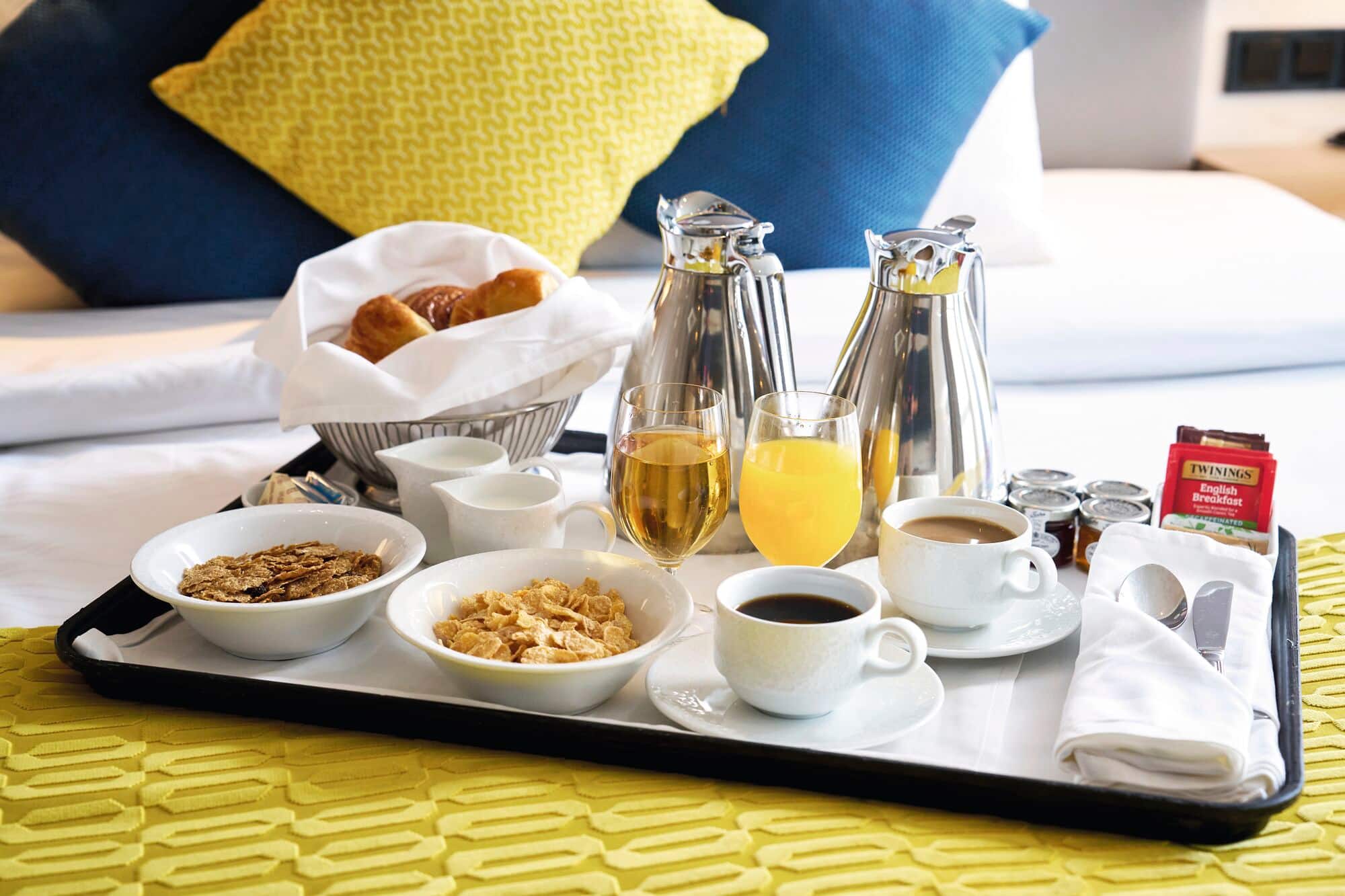 A cabin breakfast tray on a yellow bedspread.