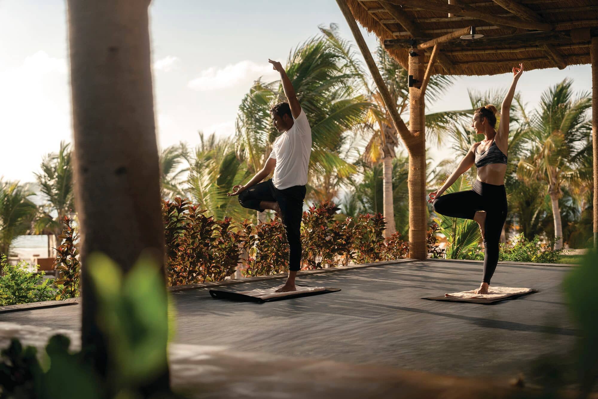 A man and a woman hold a yoga pose.
