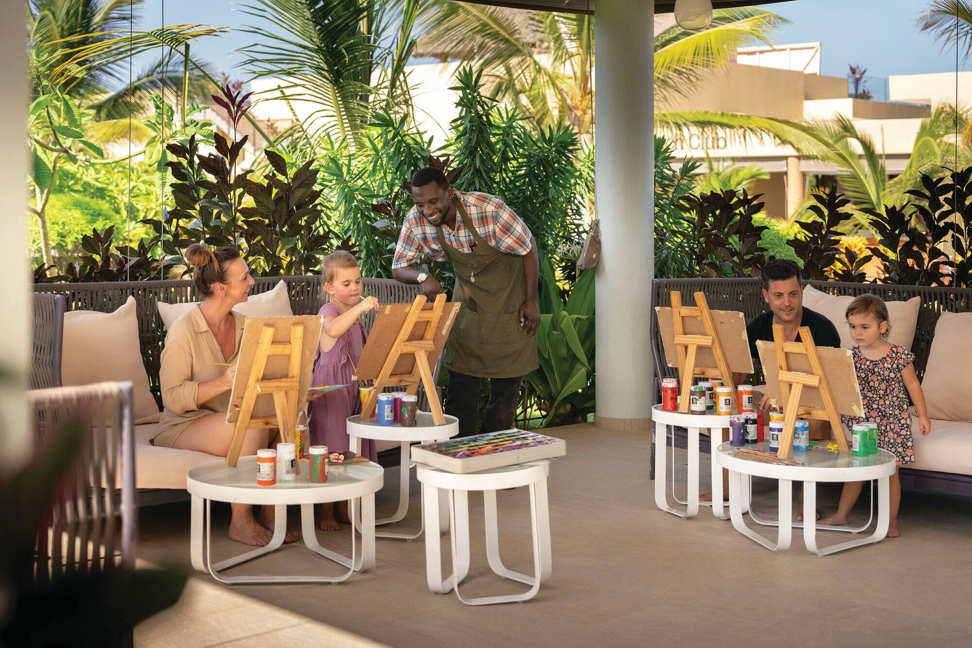 Children enjoy a painting activity with their family.