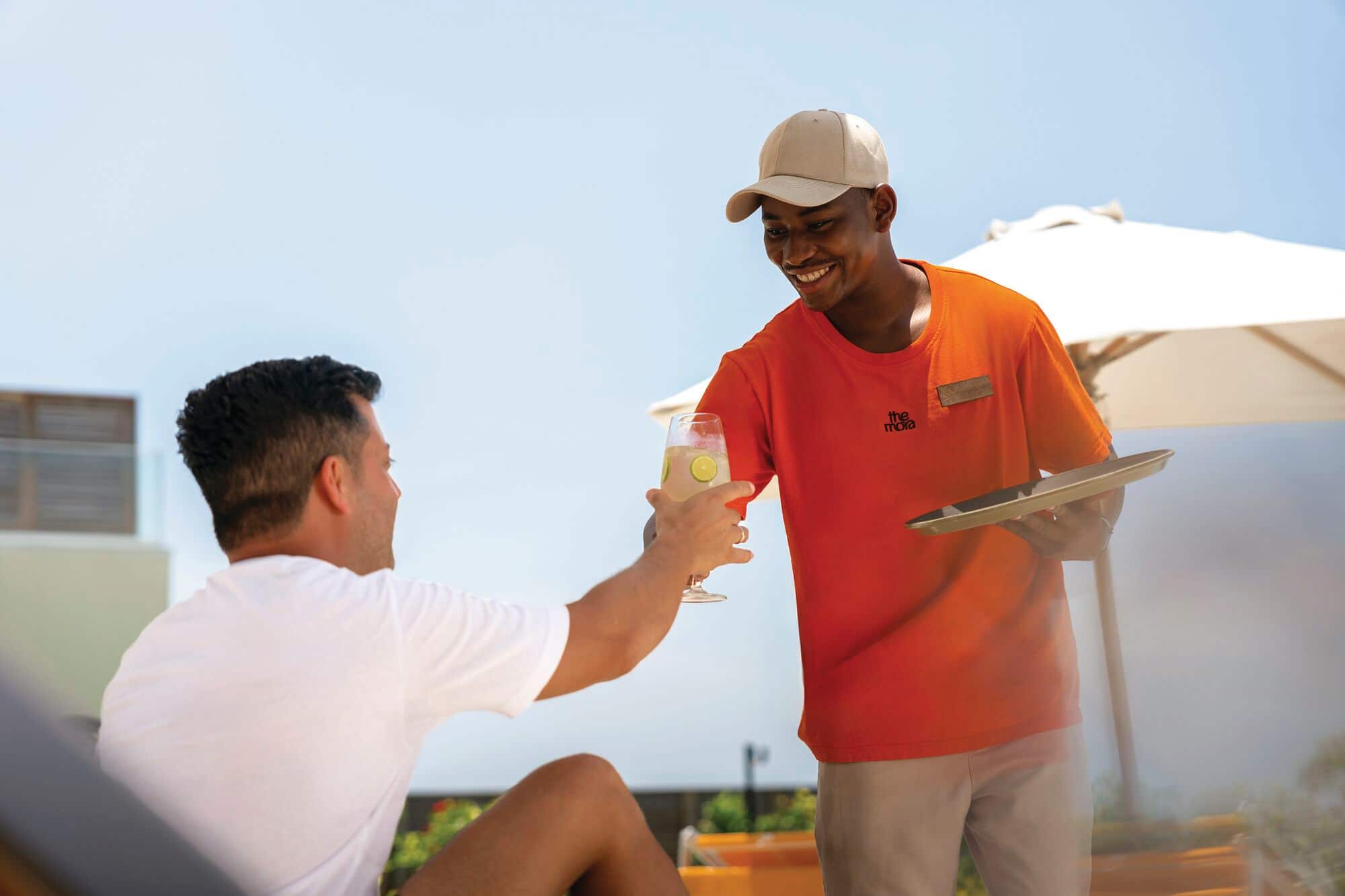 A waiter serves a glass of wine to a guest.