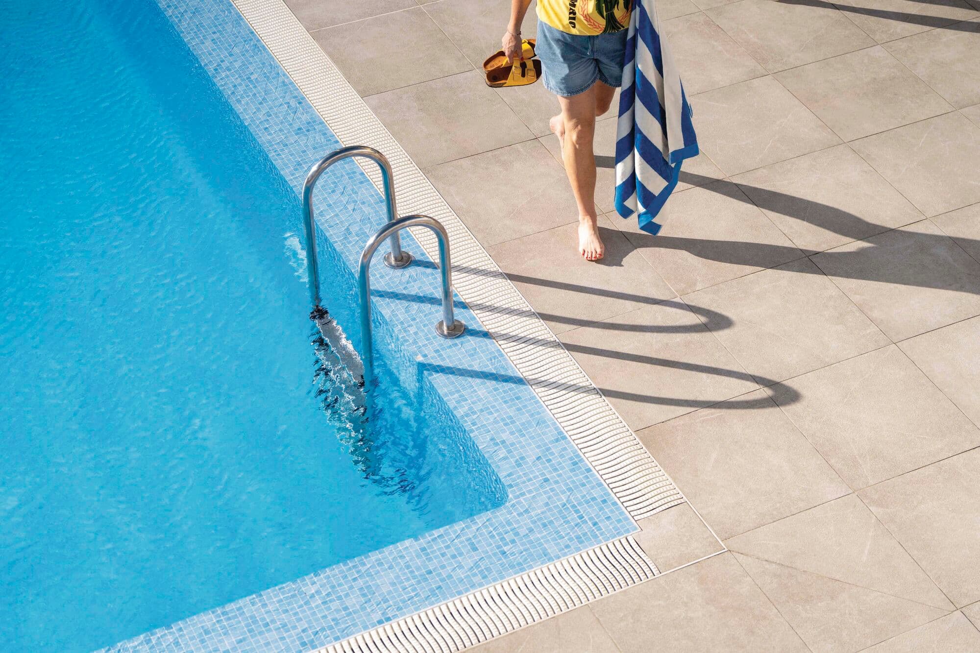 Person walking alongside the main pool.