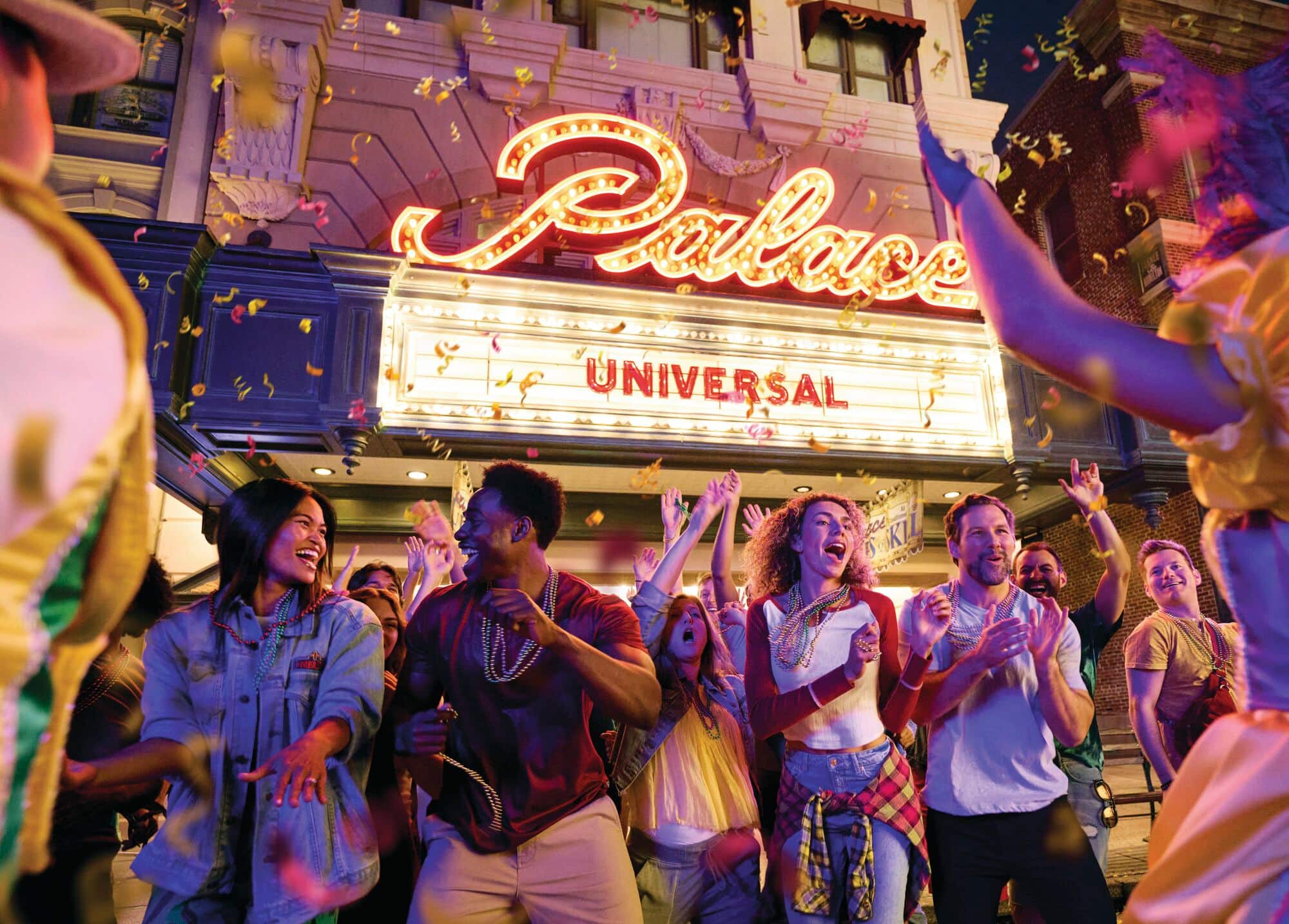 A group of people celebrating in front of a cinema entrance.