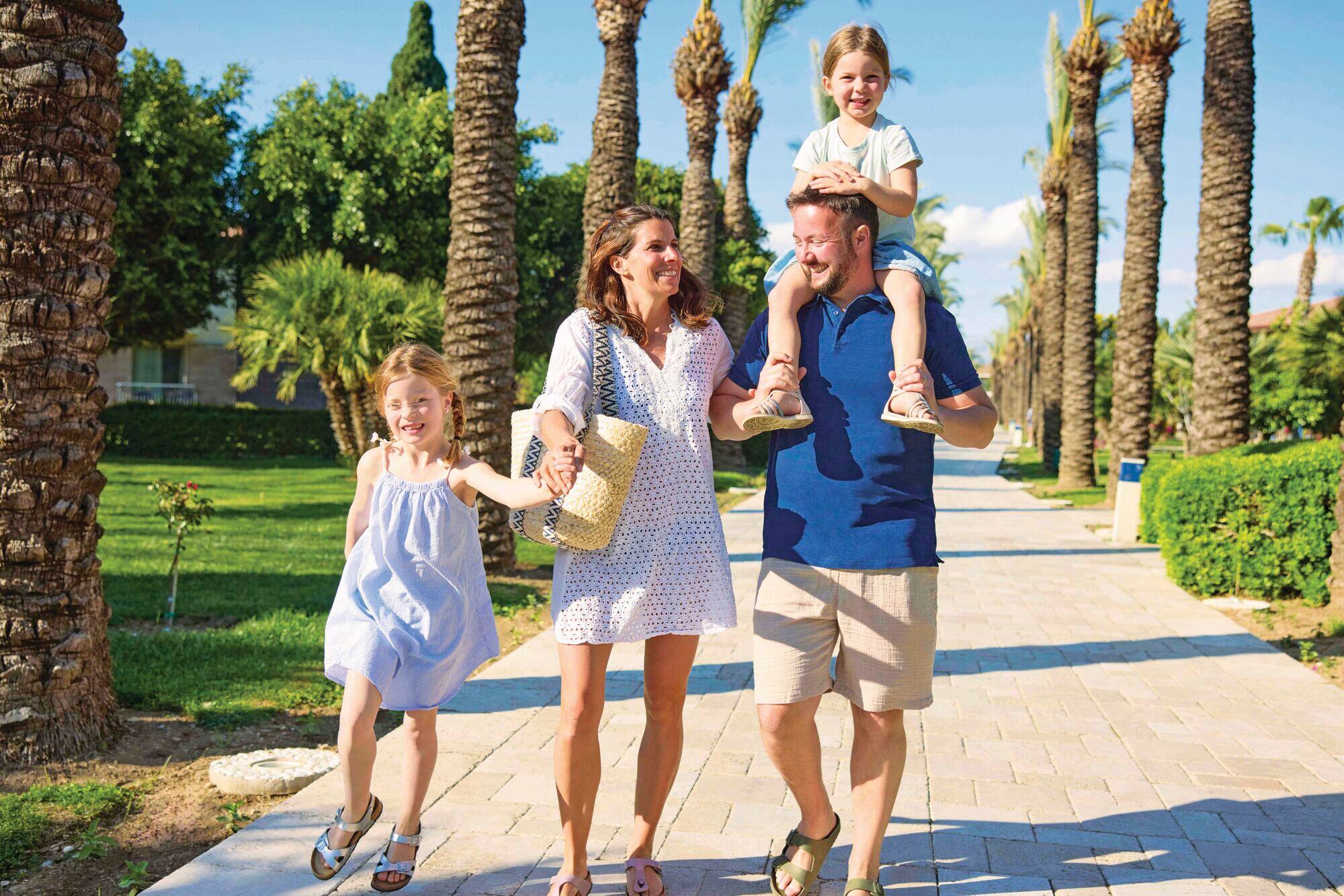A family walking along hotel grounds smiling and laughing