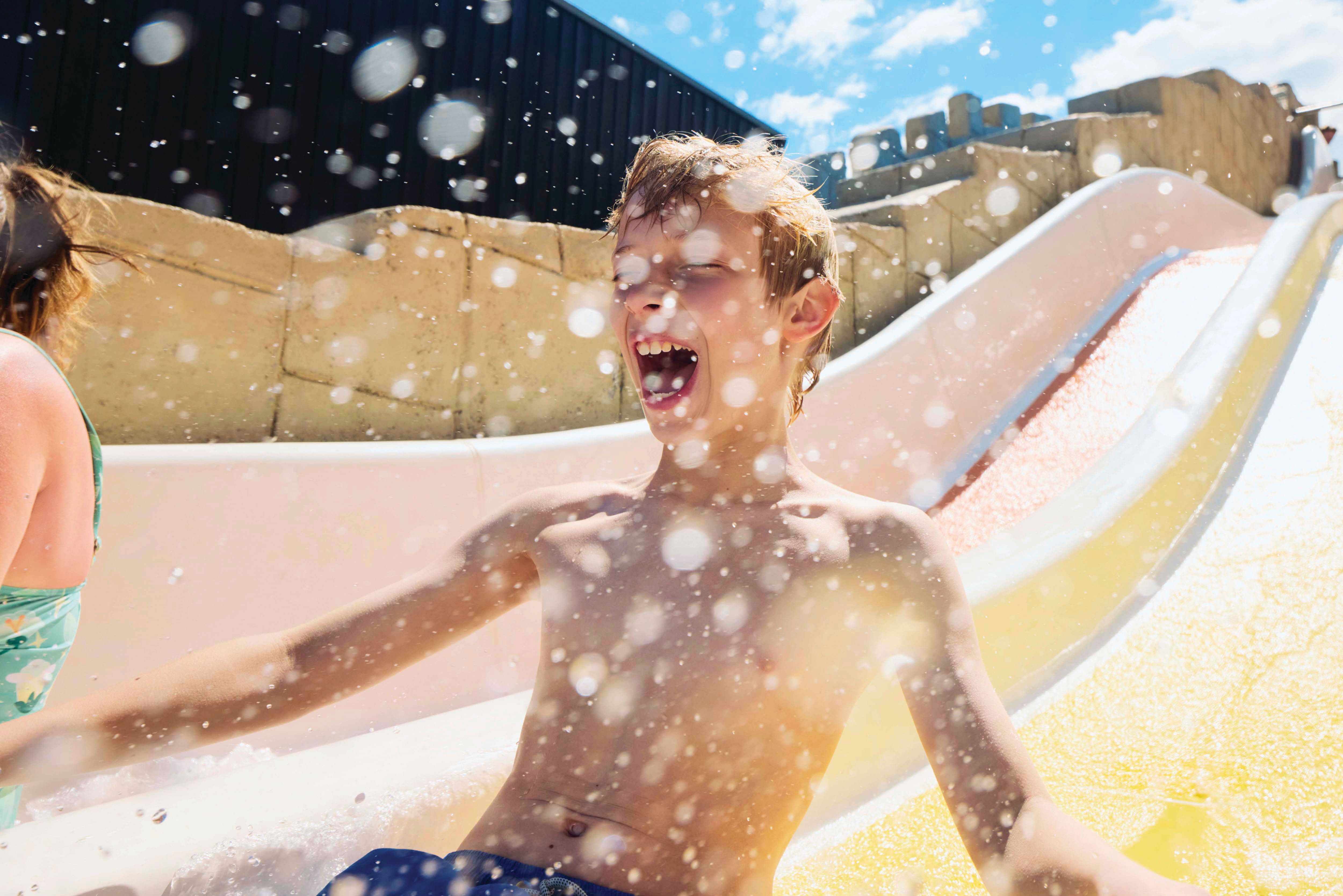 A child sliding down a colourful waterslide.
