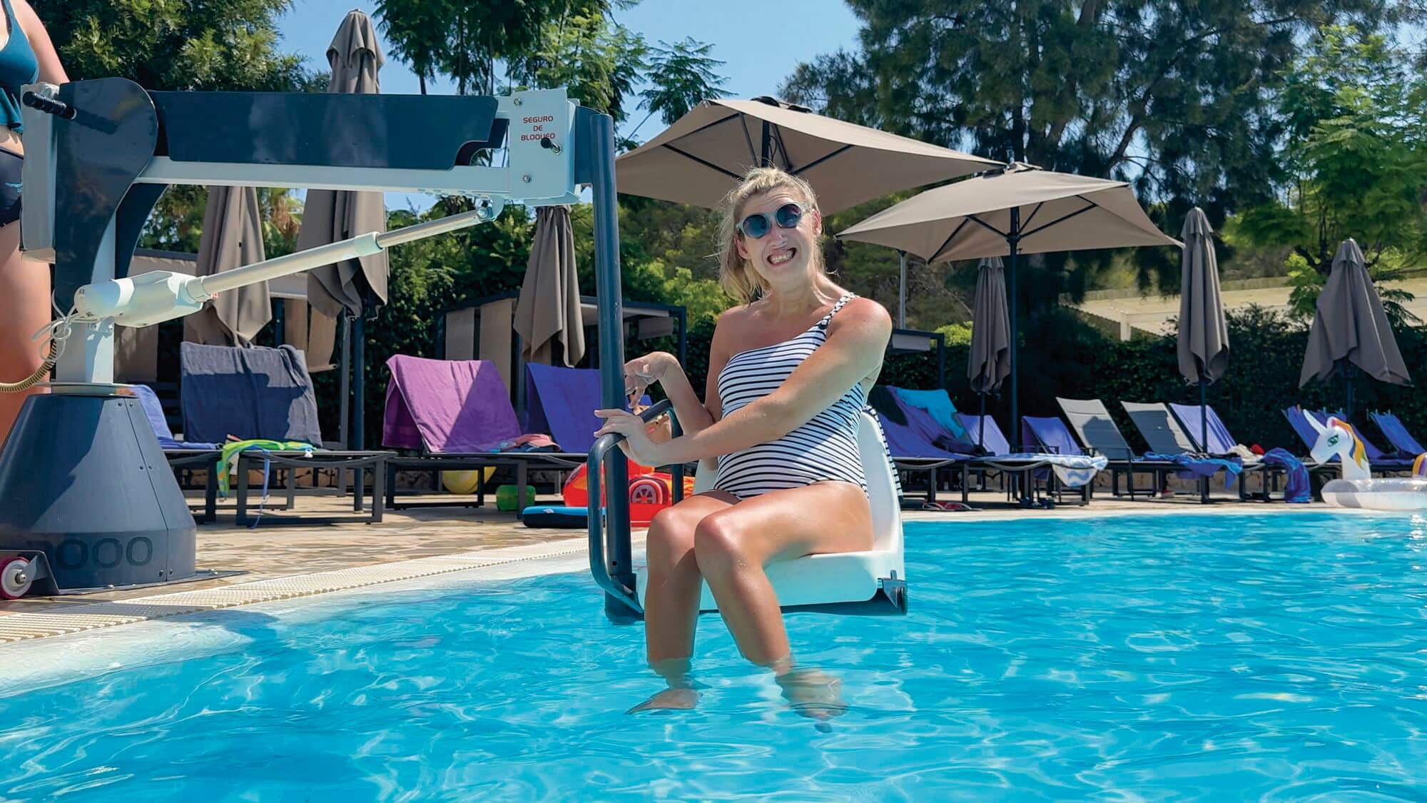 An Accessibility Ambassador using a mobility lift to enter the pool.
